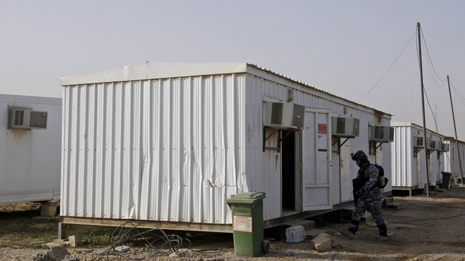 An Iraqi soldier inspects prefabricated houses at Camp Liberty, on February 17, 2012. Seventy-one members of an exiled Iranian opposition group based at Camp Liberty have been relocated to Albania, the UN said, a week after the camp suffered deadly mortar attacks.