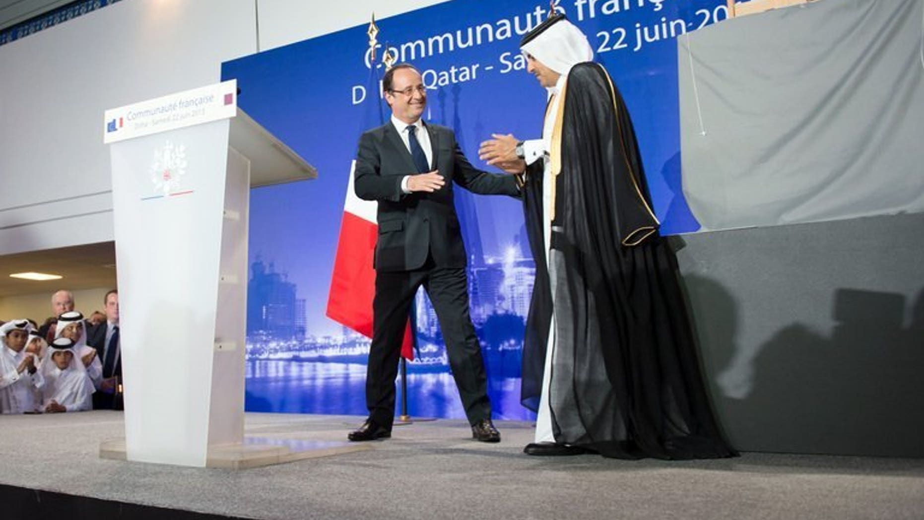 France's President Francois Hollande (L) is congratulated by Qatar's Attorney General Ali bin Mohsen bin Fetais al-Marri (R), in Doha, June 22, 2013. Hollande arrived in Qatar for talks on the deadly Syrian conflict and economic ties with the gas-rich Gulf state.