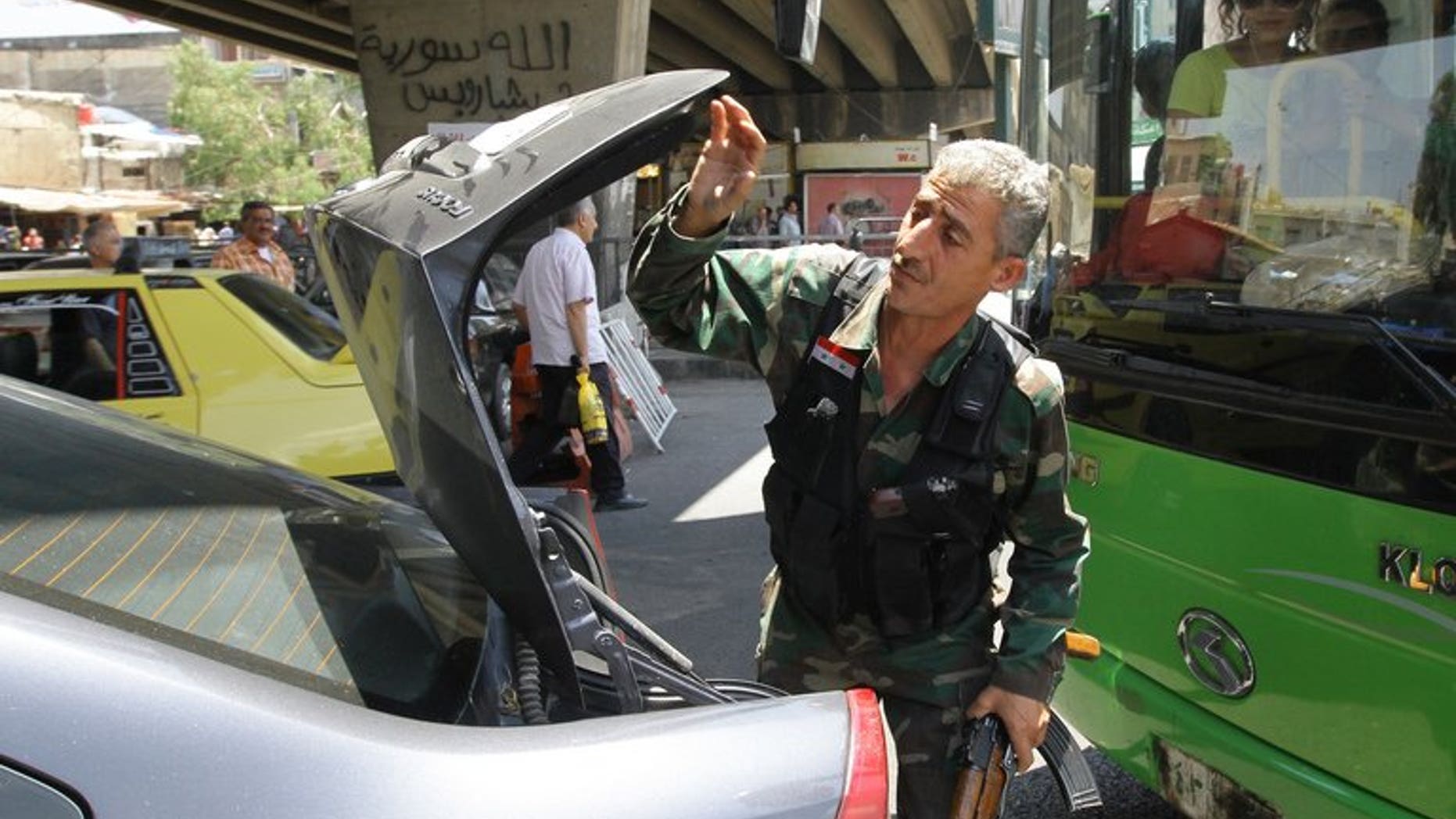 A Syrian soldier checks the trunk of a car at a checkpoint in Damascus on June 17, 2013. A suicide attack Sunday hit the northern Damascus district of Rukn al-Din, said Syrian state television, which also cited an unknown number of casualties