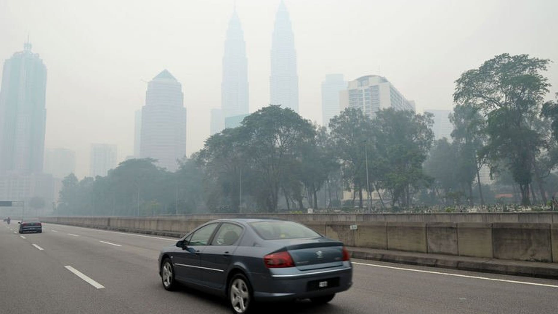 Haze shrouds Malaysia's landmark Petronas Twin Towers in Kuala Lumpur, on June 23, 2013. Malaysia's government has declared a state of emergency in two southern districts choked by smoke from forest fires in Indonesia as air pollution levels reached a 16-year high on Sunday.