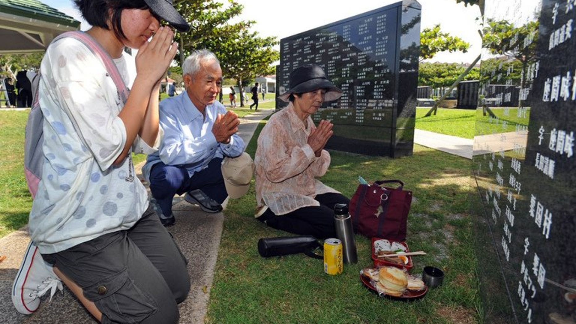 Relatives of victims killed at the 'Battle of Okinawa' pray during a memorial service at the Peace Memorial Park in Itoman, on June 23, 2013. Okinawa has marked the 68th anniversary of a bloody World War II battle, with Japan's prime minister vowing to "lighten the burden" of local residents opposed to a heavy US military presence on the southern Japanese island.