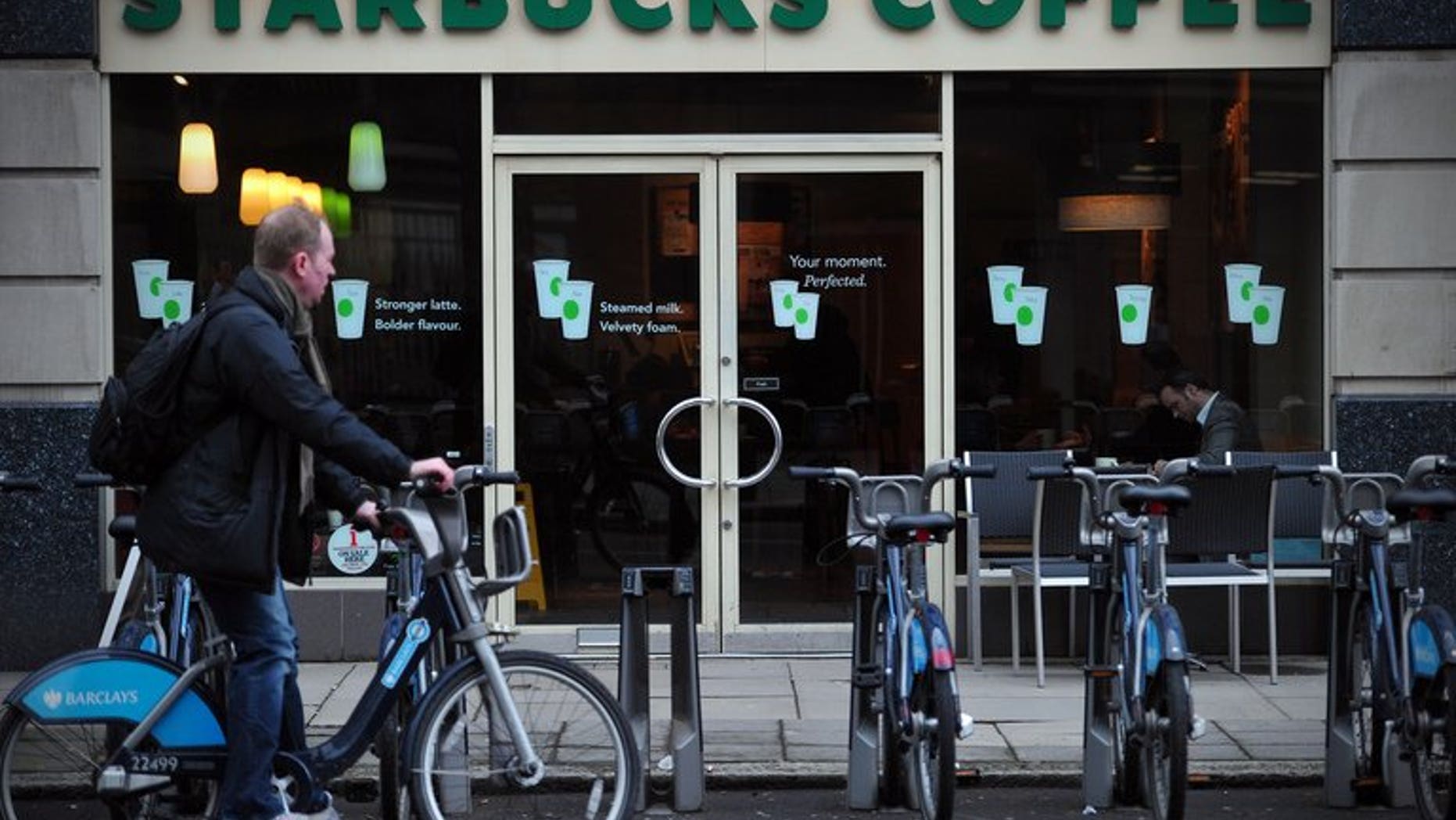 A man parks his hire bicycle outside a branch of Starbucks in central London on February 1, 2013. The US-based coffee giant has said it had paid ??5 million in British corporation tax and will pay another ??15 million by next year after facing a backlash from lawmakers and customers over non-payment.