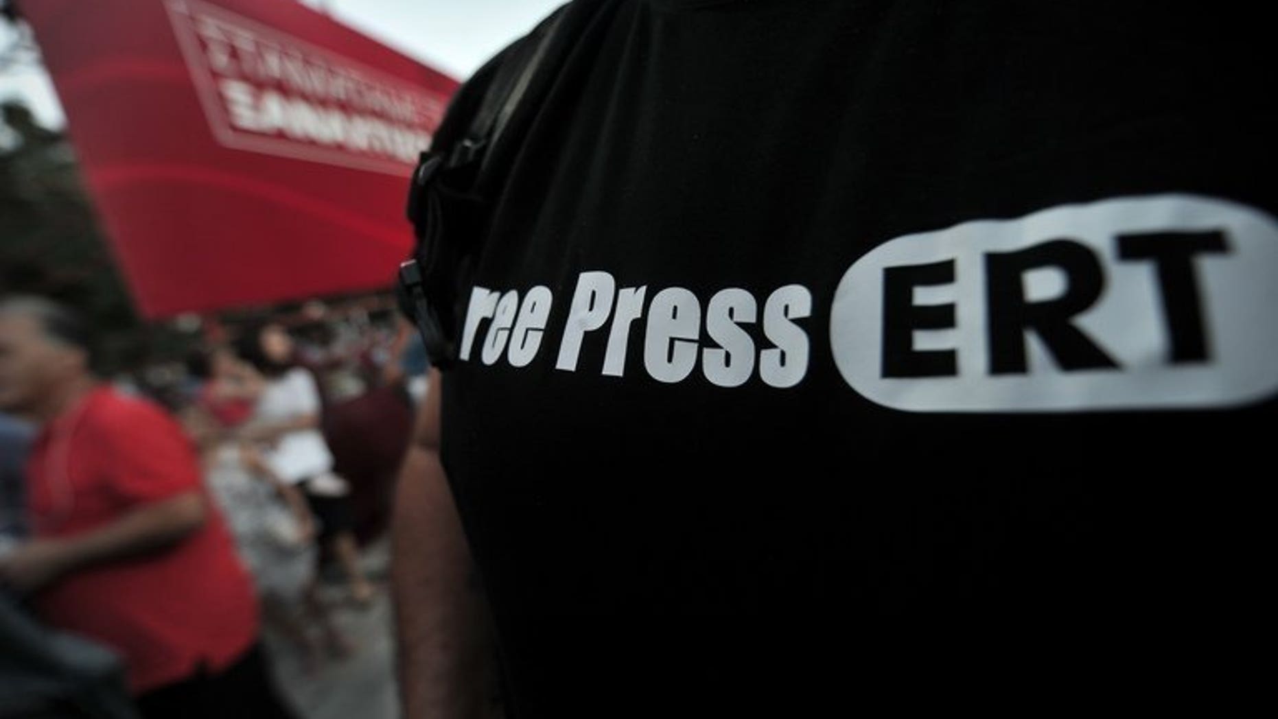 An opposition supporter wears a "Free Press ERT" T-shirt during a rally in Athens, on June 17, 2013. As debate swirls in Greece over the future of public broadcasting, analysts say the abrupt shutdown of state broadcaster ERT is only the latest problem to hit Greece's chaotic media scene.