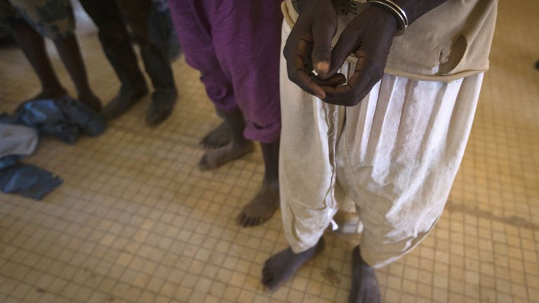 Prisoners are taken out of a jail in the northern Malian city of Gao on February 26, 2013 to be transferred to Bamako, where they were to be judged on charges of belonging to MUJAO, an Al-Qaeda offshoot. MUJAO on Sunday offered to free one of a group of Algerian diplomats kidnapped last year in exchange for the release of three "mujahedeen" held in Algeria.