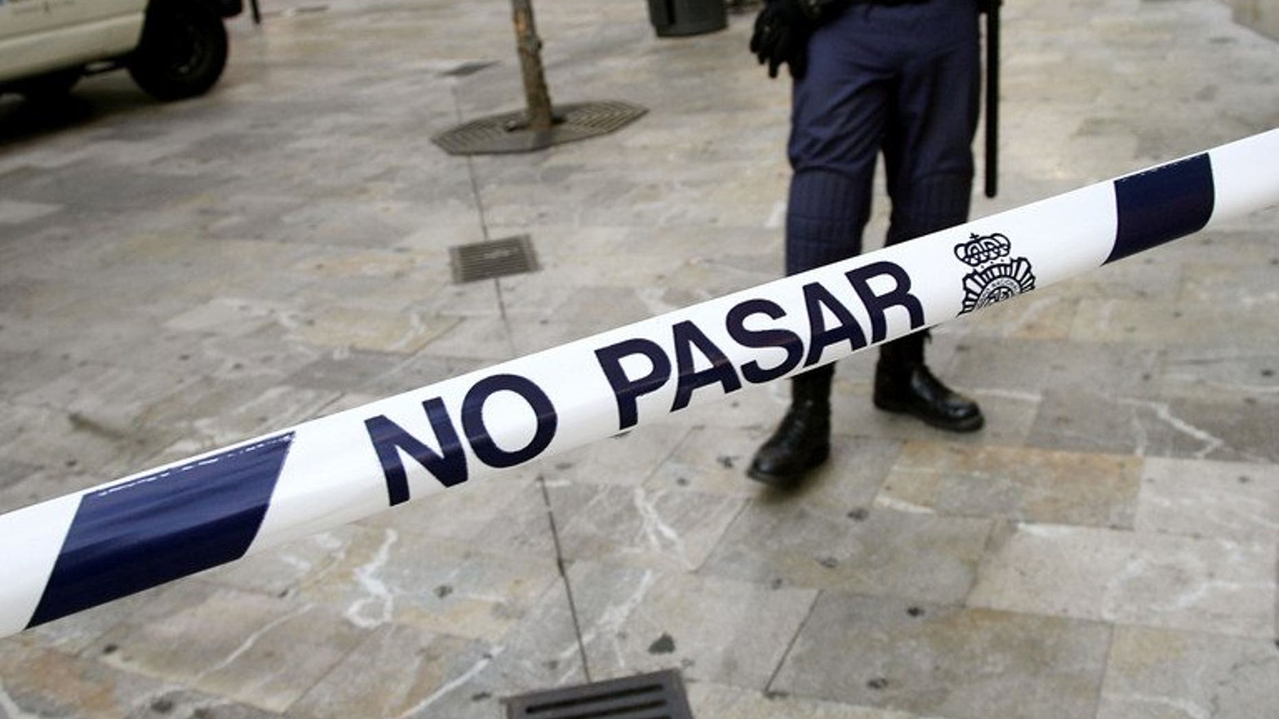 Spanish security personnel man a police cordon. A woman has been arrested for attempted murder after her two-day old baby was discovered inside a building's drains in Alicante and painstakingly rescued by firefighters.