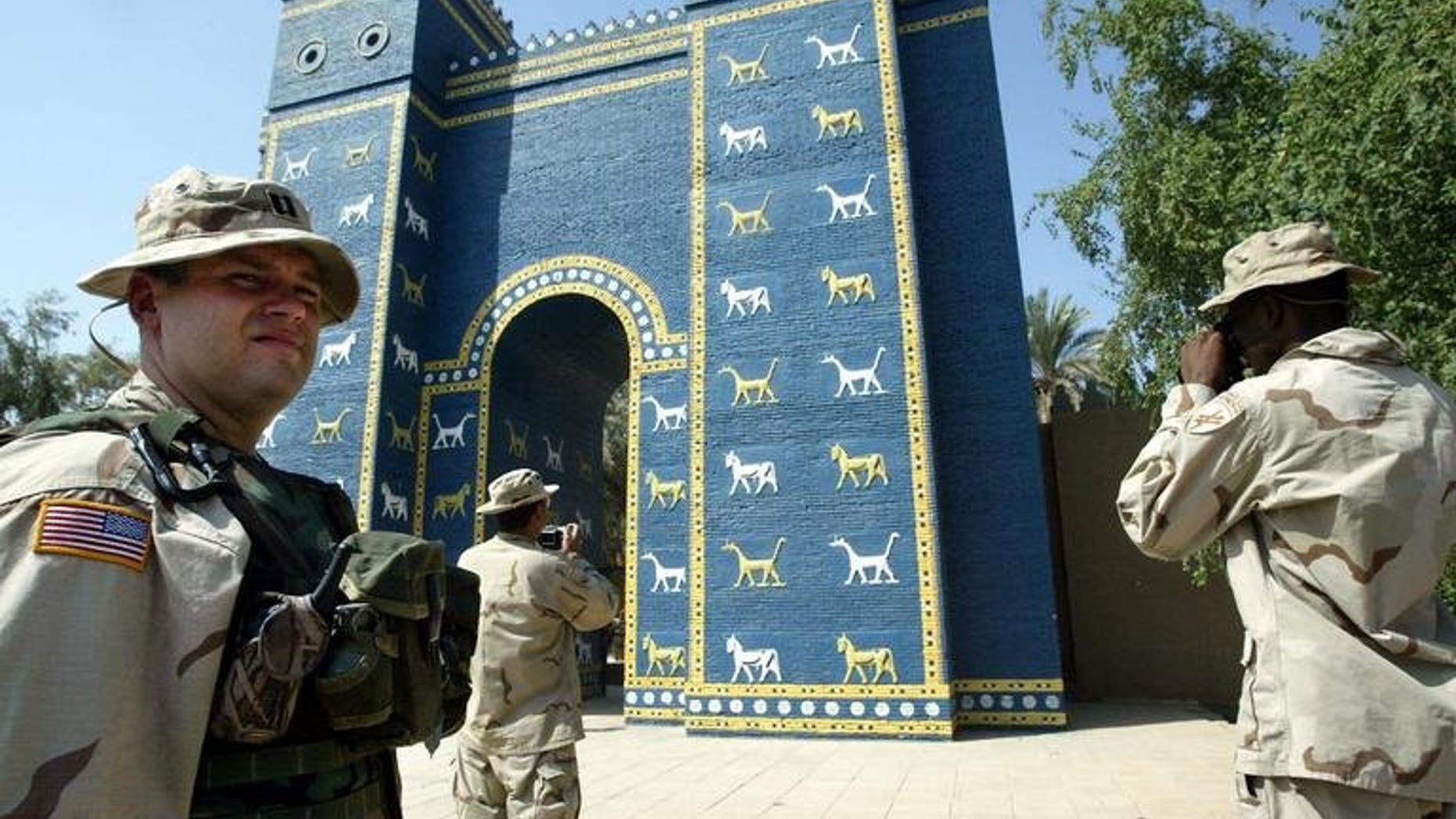 US soldiers take pictures of the Ishtar Gate in the ancient city of Babylon, on September 28, 2003. At ancient Babylon's Ishtar Gate -- workers labour with a heavy saw, hammers, a chisel and crowbar to break up and remove a concrete slab that is hastening the structure's decay.