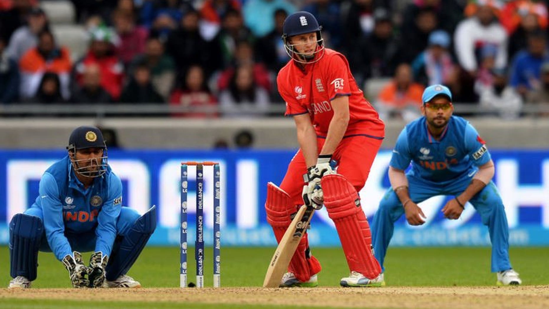 England's Joe Root plays a shot as Indian Captain Mahendra Singh Dhoni (L) and India's Virat Kohli looks on during the 2013 ICC Champions Trophy Final cricket match between England and India at Edgbaston in Birmingham, central England on June 23, 2013. England said Monday rising star Root was "currently the best opening partner for Alastair Cook" as they left Nick Compton out of their squad.