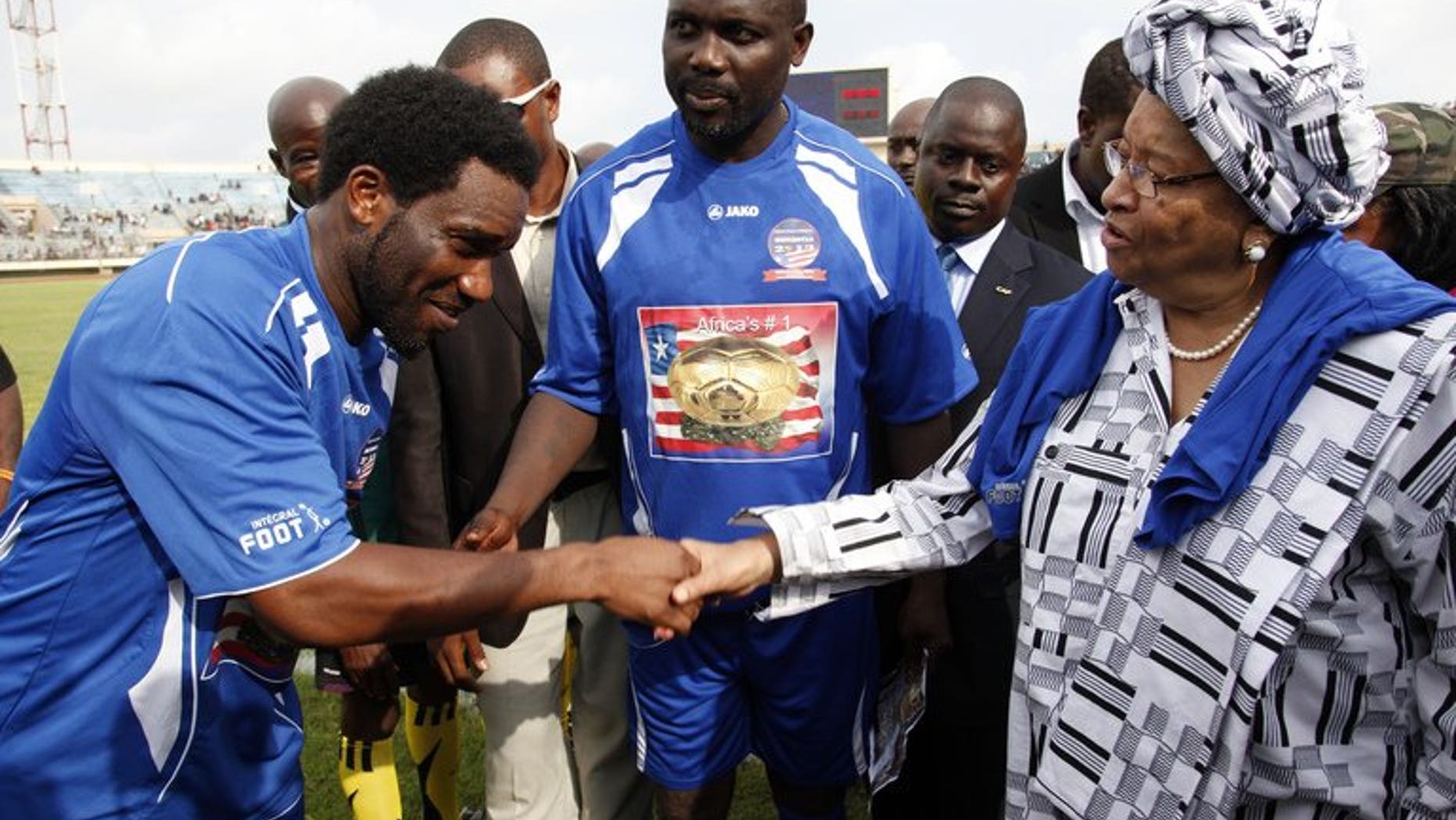 Former football player Jay Jay Ochocha (L) shakes hands with Liberian President Ellen Johnson Sirleaf (R) next to Liberia's former football star George Weah (C) on June 22, 2013. Weah has been joined by legends of the game from across Africa to promote reconciliation in his homeland more than a decade after civil wars which killed 250,000 people.