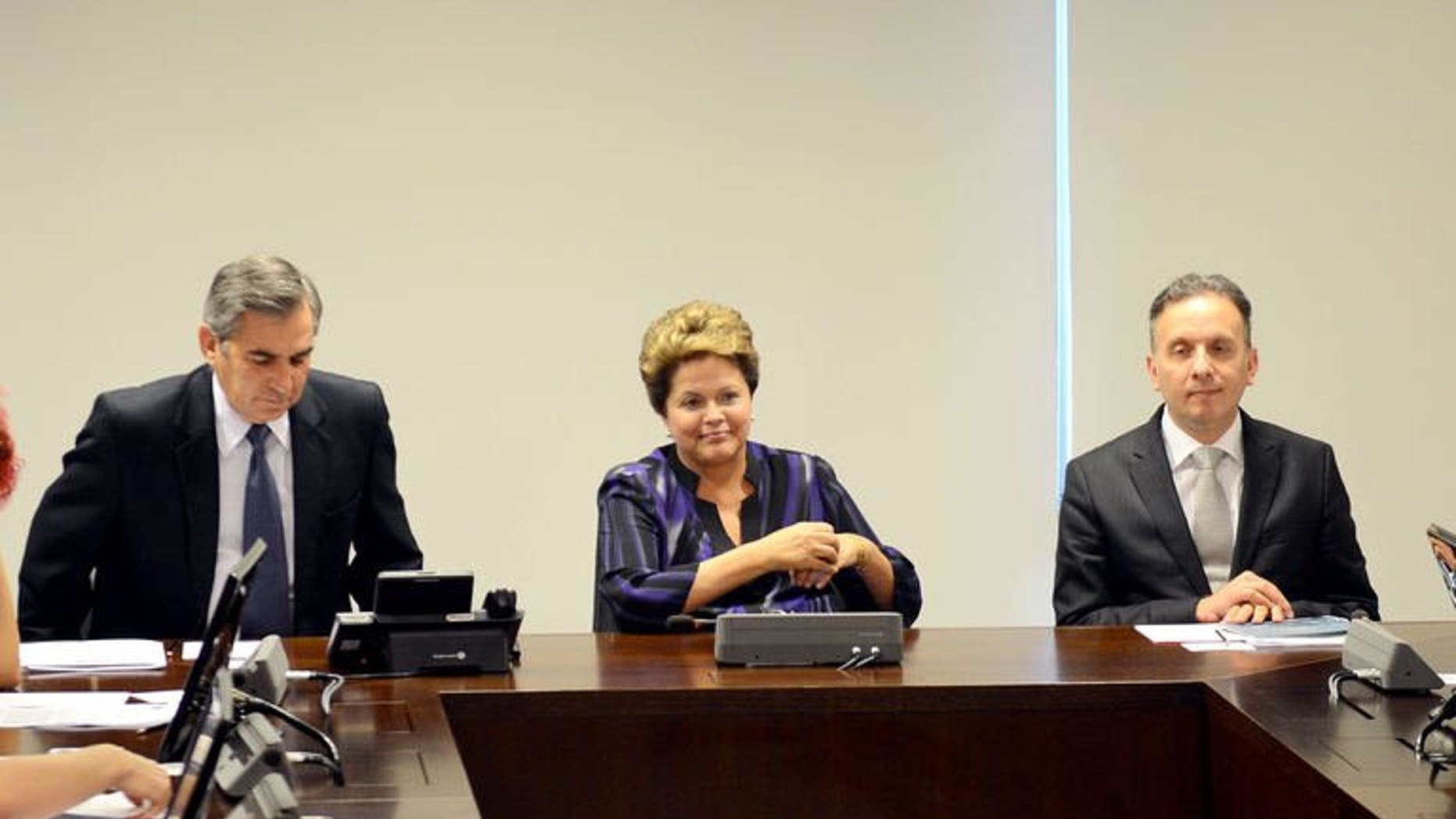Brazilian President Dilma Rousseff (C), General Secretary of the Presidency Gilberto Carvalho (L) and the Minister of Cities Aguinaldo Ribeiro are seen during a meeting at the Planalto Palace in Brasilia on June 24, 2013. Rousseff on Monday proposed to earmark $25 billion for public transport following massive nationwide street protests over the country's inadequate mass transit system.