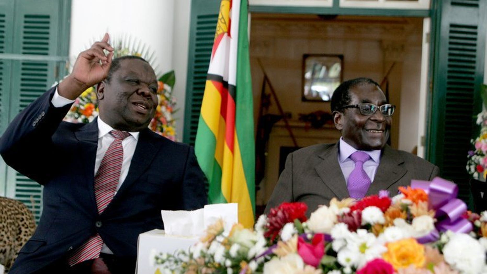 Zimbabwe's Prime Minister Morgan Tsvangirai (L) and President Robert Mugabe at the conclusion of the constitution-making process at State House on January 17, 2013 in Harare. Tsvangirai has filed an application with the country's top court for a delay of elections to allow key reforms to take effect, court papers showed.