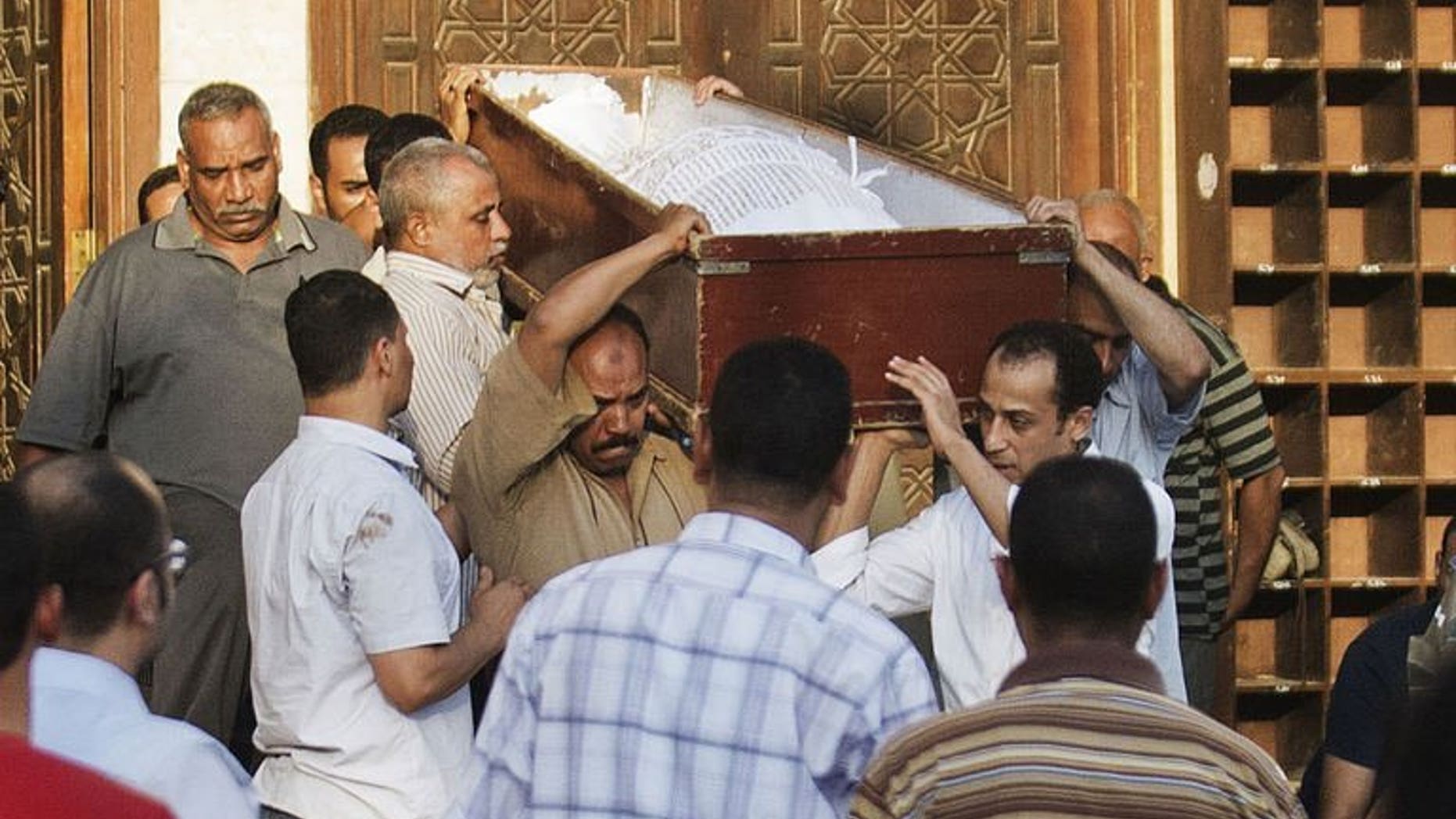 People carry the coffin of a Shiite man killed the previous night by a mob along with three others, during his funeral in El-Sayeda Nafisa Mosque in Cairo on June 24, 2013. Security forces have arrested eight people in connection with the brutal killing of four Egyptian Shiites in a village south of Cairo, officials said on Tuesday.