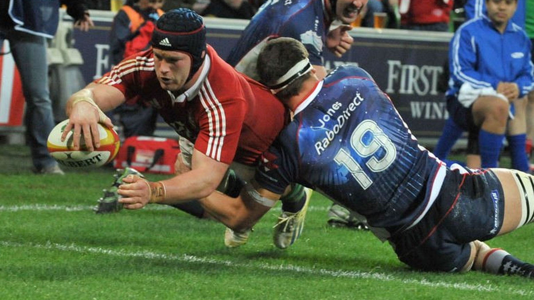 British and Irish Lions' flanker Sean O'Brien (left) dives over the try line to score a try against the Melbourne Rebels on June 25, 2013. The Lions scored five tries to beat the Melbourne Rebels 35-0 in their tour game in Melbourne.
