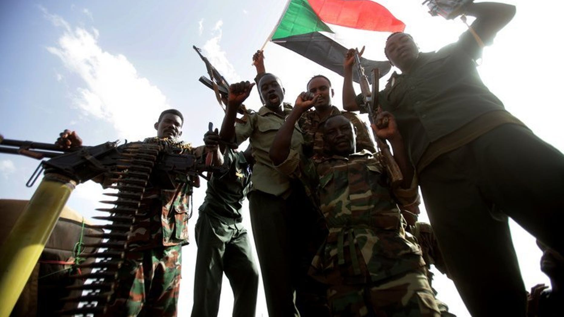 Sudanese soldiers cheer as they hold up their guns and a national flag during President Omar al-Bashir's visit to Sudan's main petroleum centre of Heglig on April 23, 2012. A new general took command of the Sudan Armed Forces (SAF) on Tuesday after what analysts called humiliating attacks by anti-government rebels.