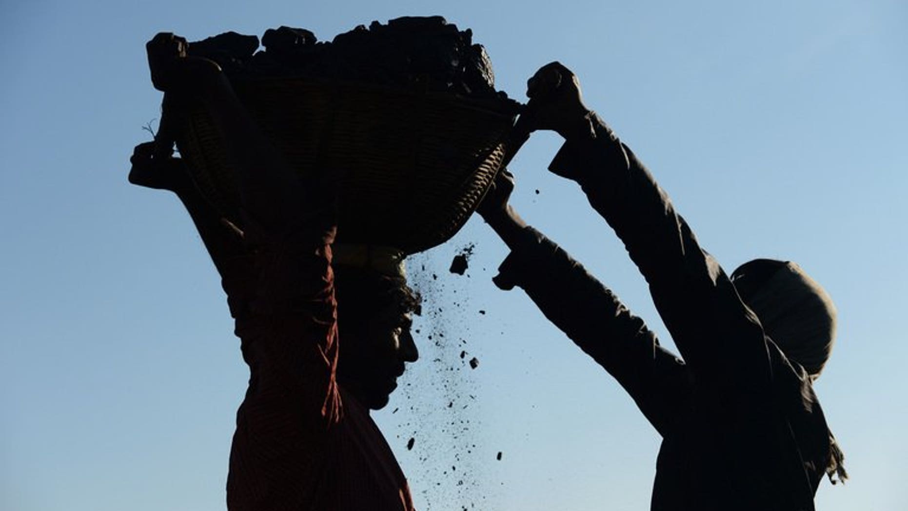 In this photograph taken on January 31, 2013, miners haul baskets full of coal as they load a truck with coal at a road side coal depot near Rymbai village in the Indian northeastern state of Meghalaya. Eight coal miners have been beaten to death and three more are critically injured in India's northeastern state of Meghalaya, officials said on Tuesday.
