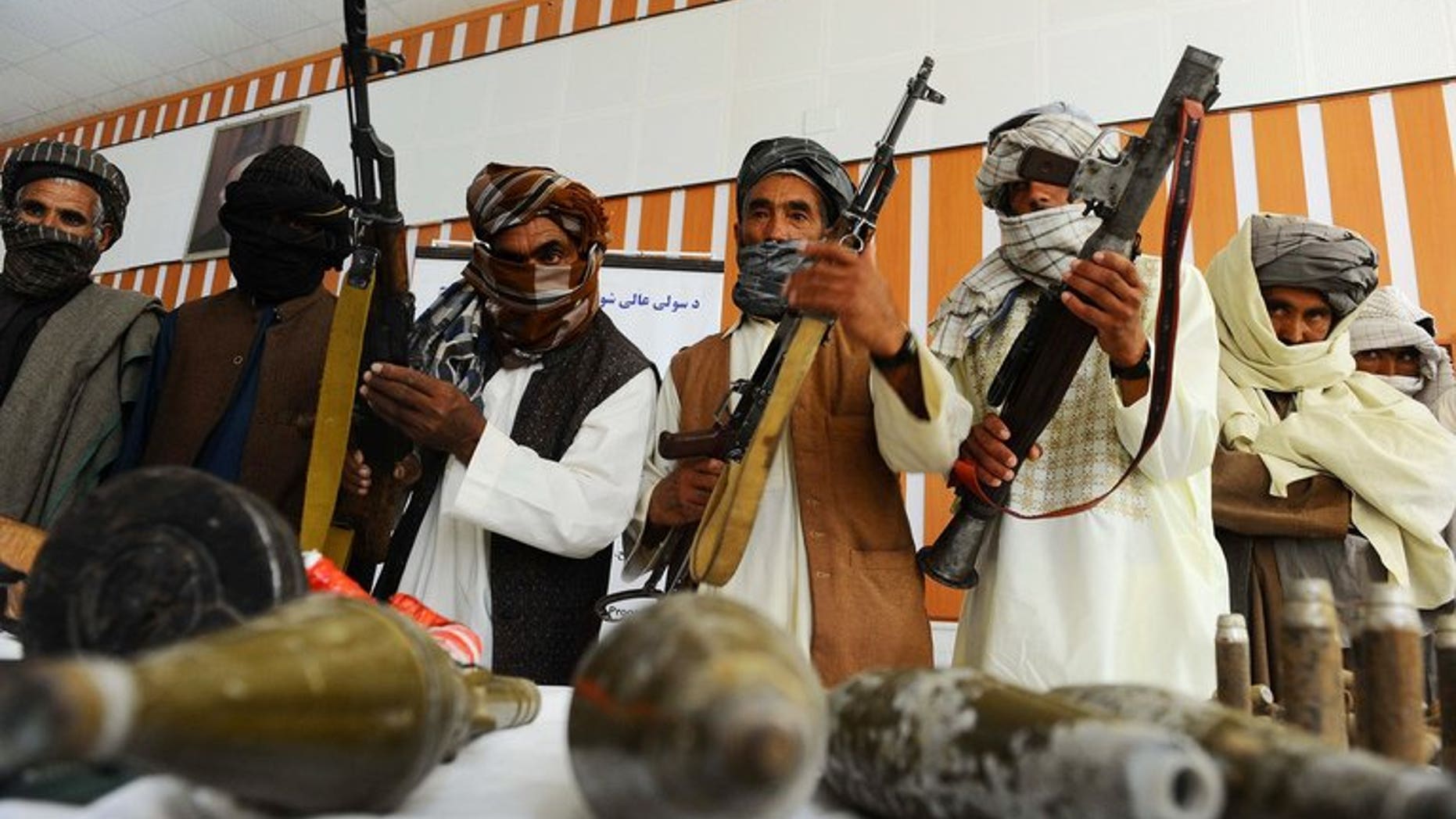 Former Taliban fighters show their weapons to the media, after joining Afghan government forces, in Herat, on June 26, 2013. The US said on Thursday that it expected the Taliban to continue to mount attacks in Afghanistan even as the rebels hold peace talks from their new office in Qatar.