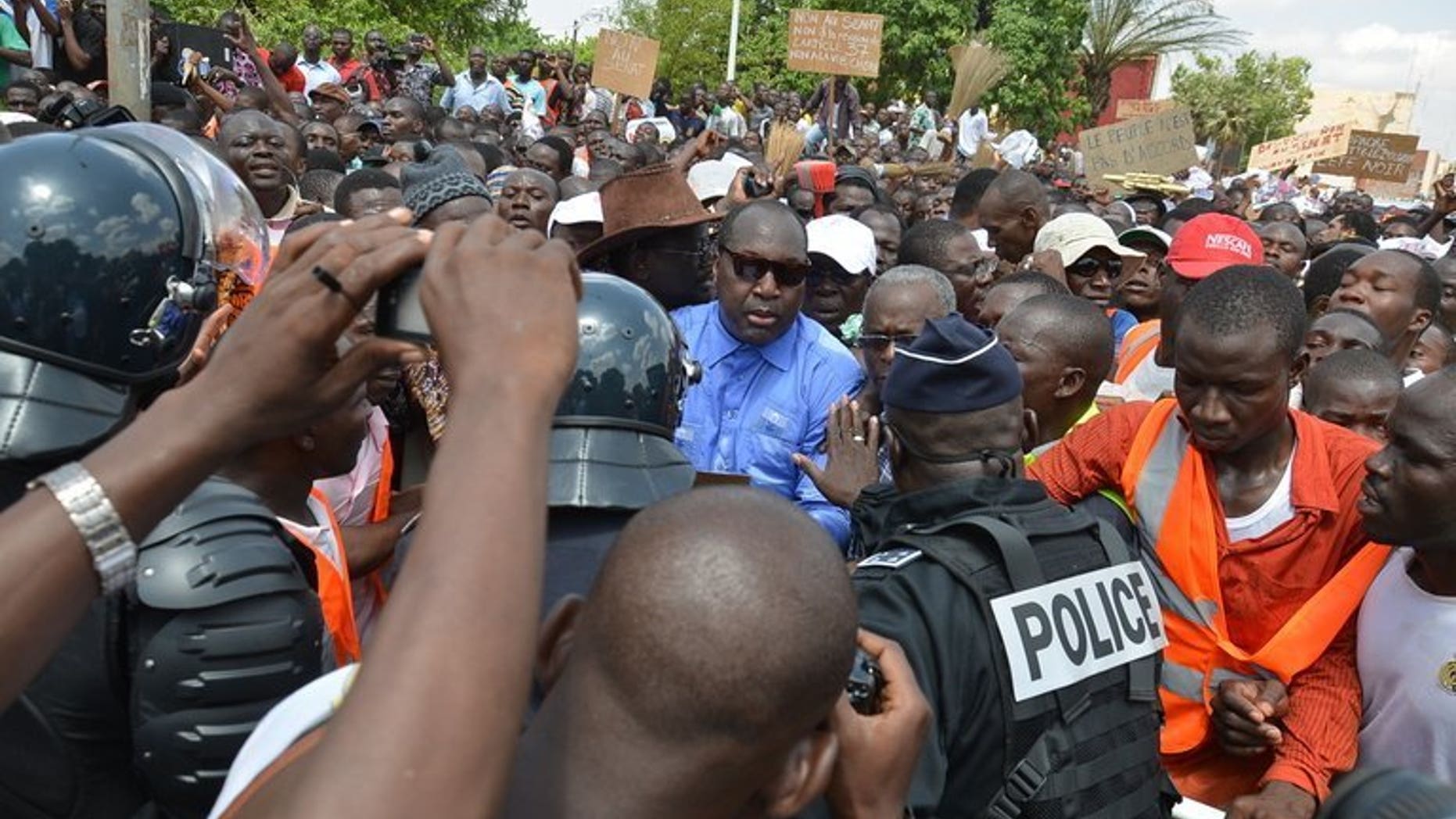 Opposition leader, Zephirin Diabre (C-blue shirt) and supporters face policemen during a demonstration against the government on June 29, 2013 in Ouagadougou. Police in Burkina Faso fired tear gas Saturday to disperse demonstrators protesting against the creation of a Senate, which they say will enable President Blaise Compaore to extend his 26-year rule.