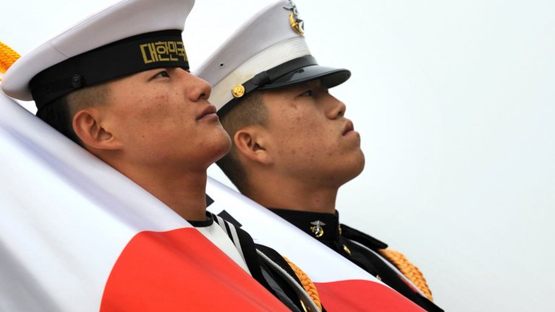 South Korean military honour guards carry Japanese flags, in Seoul, in 2010. Japan's foreign minister will hold direct talks with his South Korean counterpart at a regional gathering this week, the first ministerial meeting between the two countries since new governments came to power.