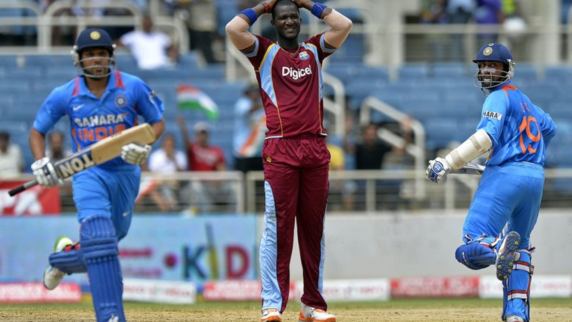 Dinesh Karthik (right) and Rohit Sharma take a run off the bowling of Darren Sammy (centre) in Kingston on Sunday. Stand-in West Indies captain Kieron Pollard won the toss and put India in to bat in the second match of the Tri-Nation One-Day International Series at Sabina Park.