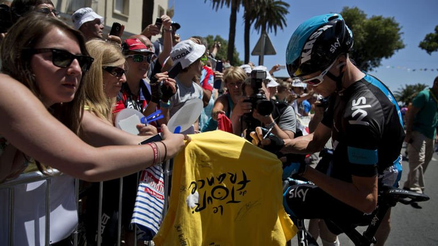 Britain's Christopher Froome signs autographs in Bastia before the start of the 156 km second stage of the 100th edition of the Tour de France cycling race on June 30, 2013 between Bastia and Ajaccio, on the French Mediterranean Island of Corsica.