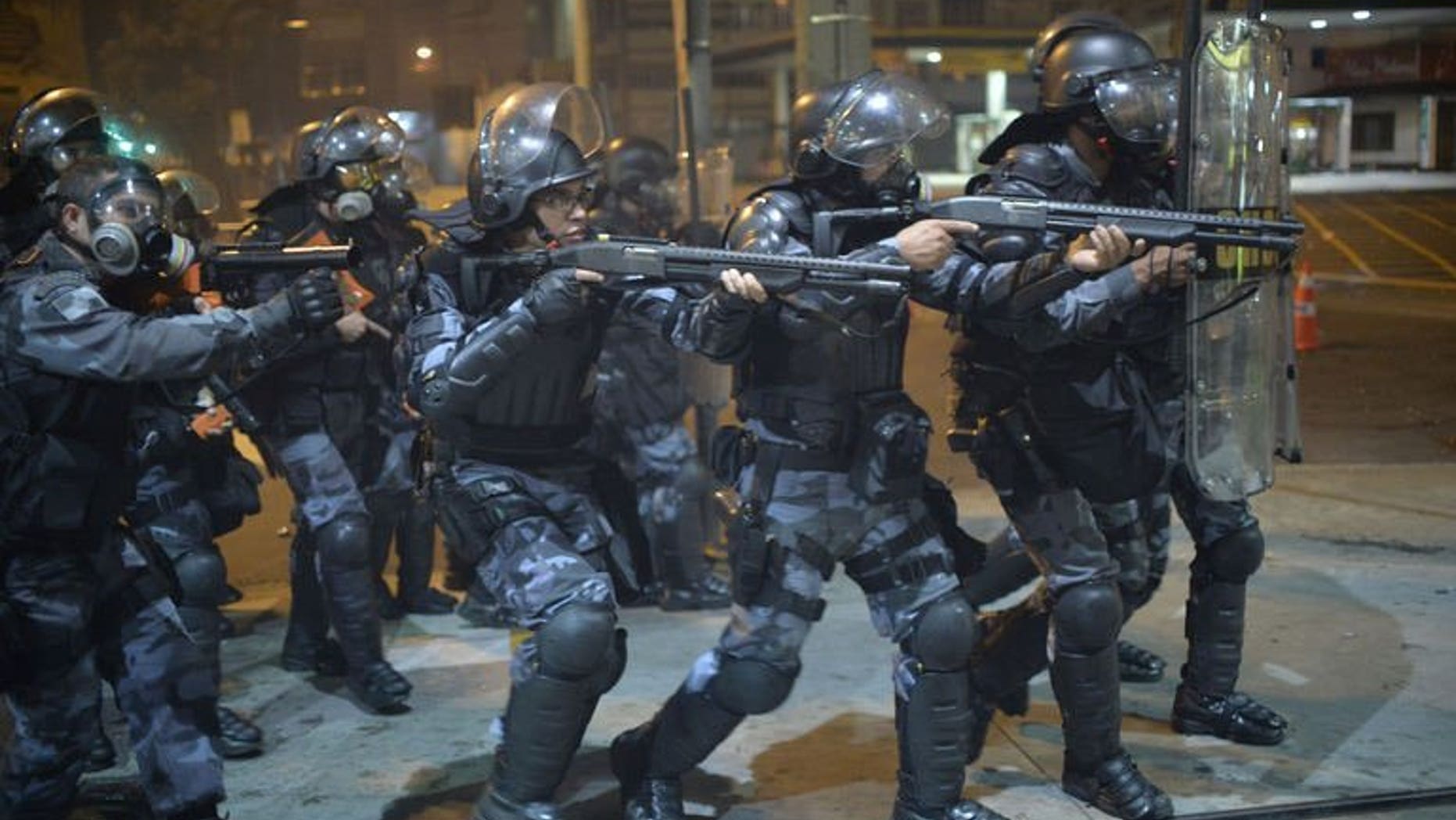 Anti riot police charge during a protest in a street near the Maracana stadium of Rio de Janeiro on June 30, 2013. Protesters clashed with police near Rio's iconic Maracana stadium Sunday, only minutes before the start of the Brazil-Spain final of the Confederations Cup, AFP correspondents reported.