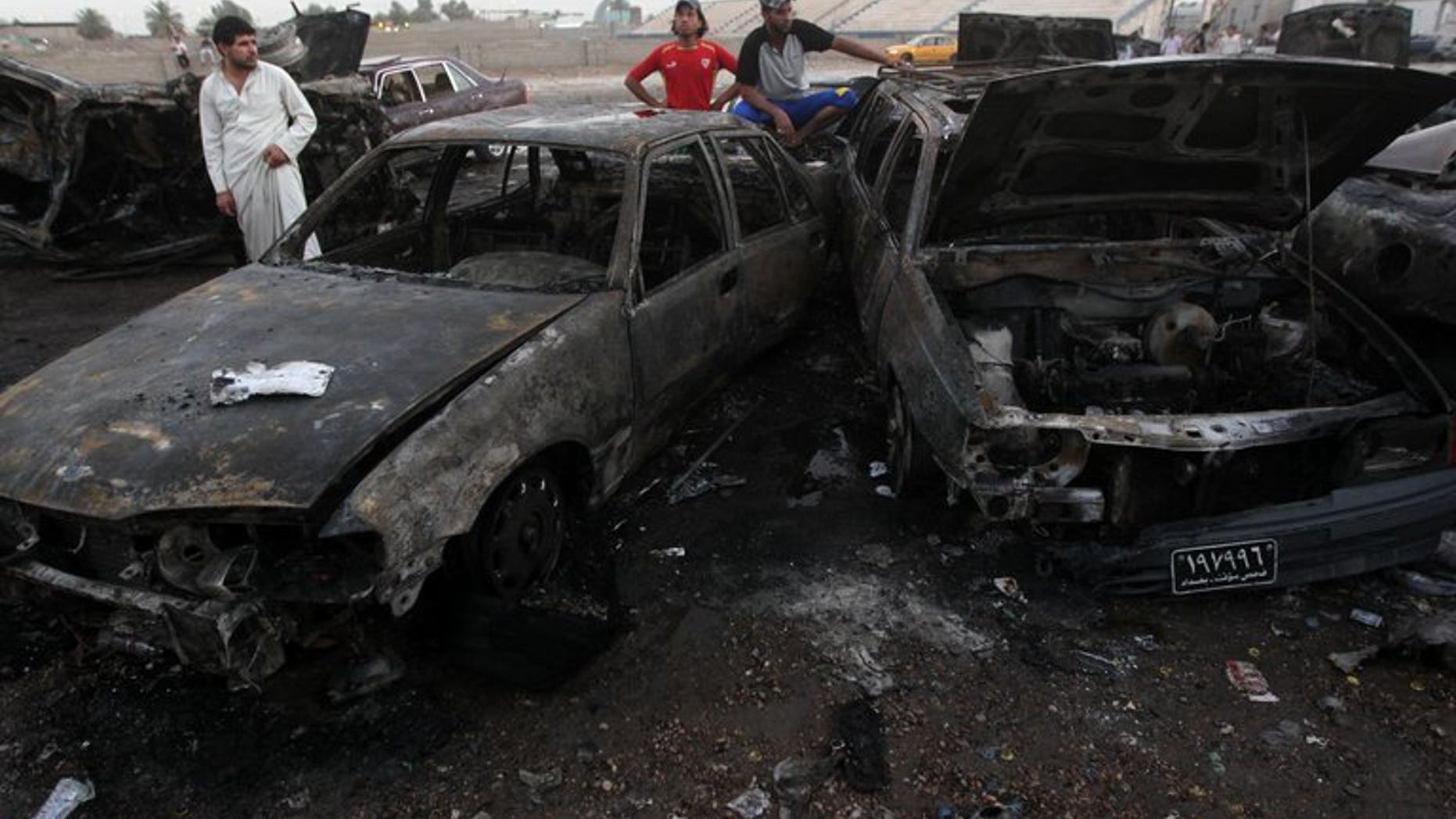 Iraqi men gather at the scene of one of a car bomb that exploded in Baghdad's Habibiyah area on May 27, 2013. More than 1,500 people were killed in Iraq in the past three months, twice the previous quarter's figure, fanning fears the politically-deadlocked country is slipping back into all-out bloodshed.