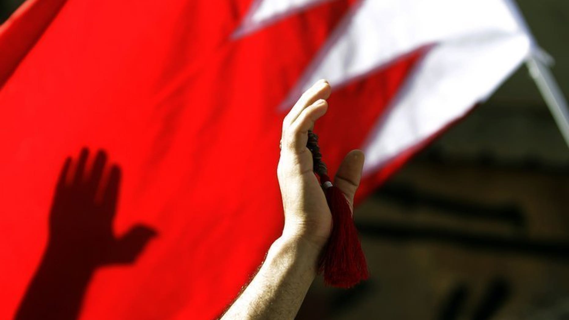 A Shiite protester waves a Bahrain flag during a rally in Manama, on March 22, 2011. A Bahraini court has acquitted two police officers, including a woman, on trial for torturing six Shiite doctors during the 2011 uprising against the Sunni regime, a judicial source said.