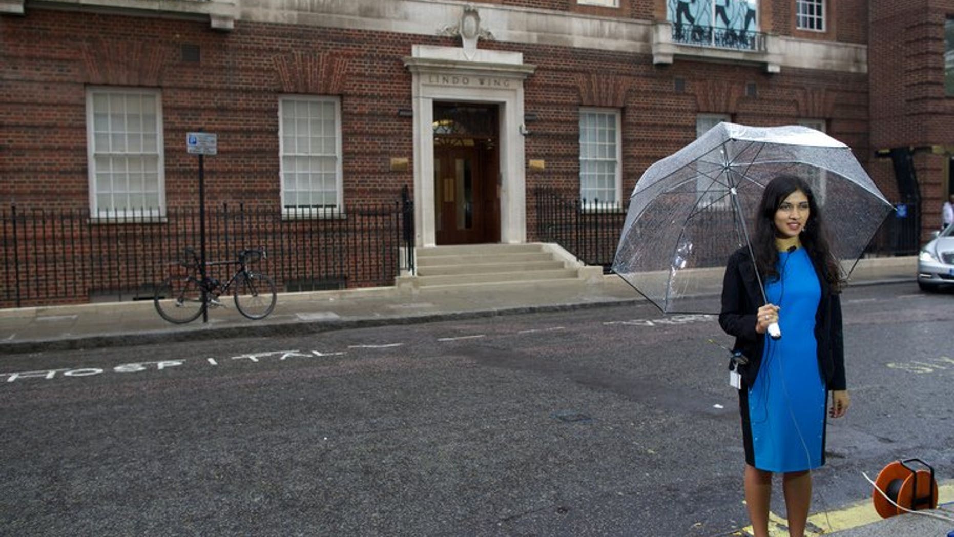 A reporter prepares to go on camera outside the Lindo Wing at St Mary's Hospital in London on June 20, 2013. Prince William's wife Catherine is not officially due to give birth for two weeks but the world's media began gathering outside the London hospital where she will have the baby, determined not to miss the photograph of the year.