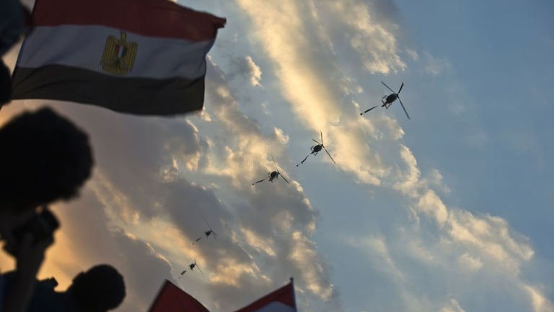 Egyptian army helicopters fly over as hundreds of thousands of Egyptian demonstrators gather outside the presidential palace in Cairo during a protest calling for the ouster of President Mohamed Morsi on July 1, 2013.