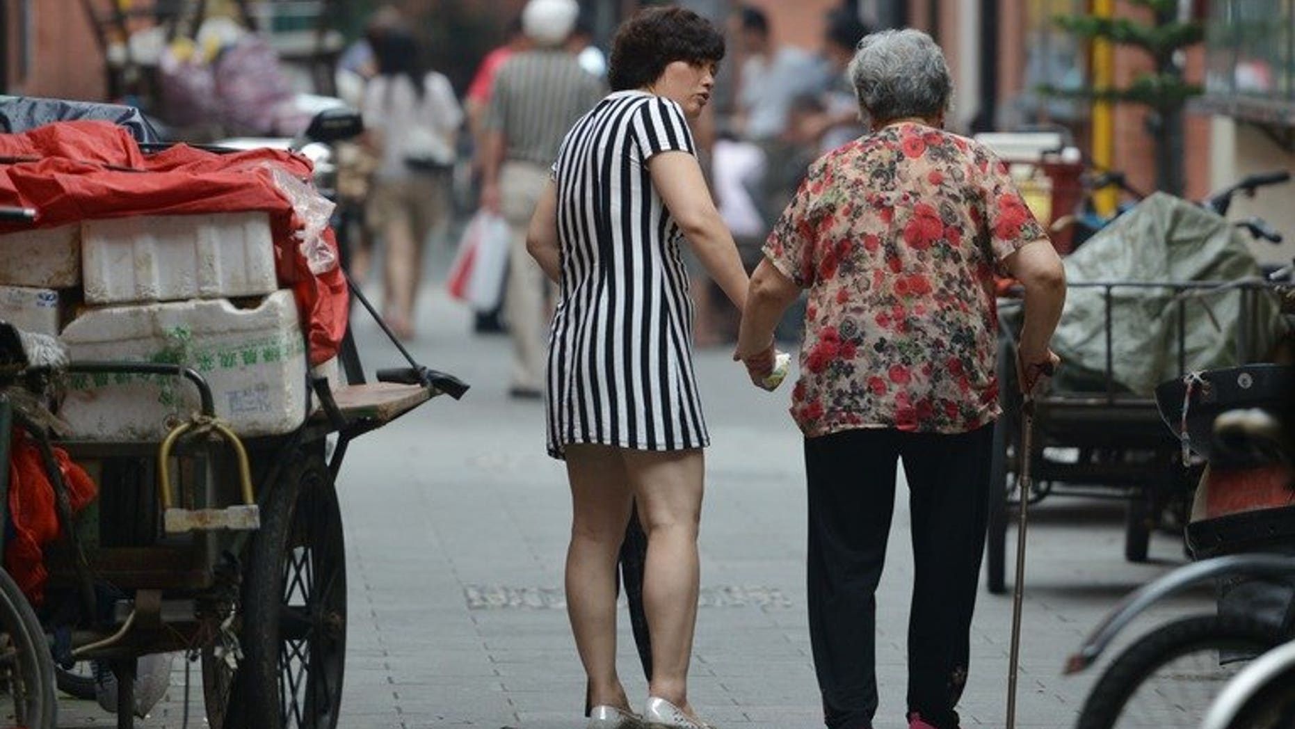 A mother and daughter are seen walking together in Shanghai, on July 1, 2013. The Law on Protection of the Rights and Interests of the Elderly says family members should visit relatives who are aged over 60 "often" -- but does not give a precise definition of the term. More than 14 percent of China's population, or 194 million people, are aged over 60, according to the most recent figures.