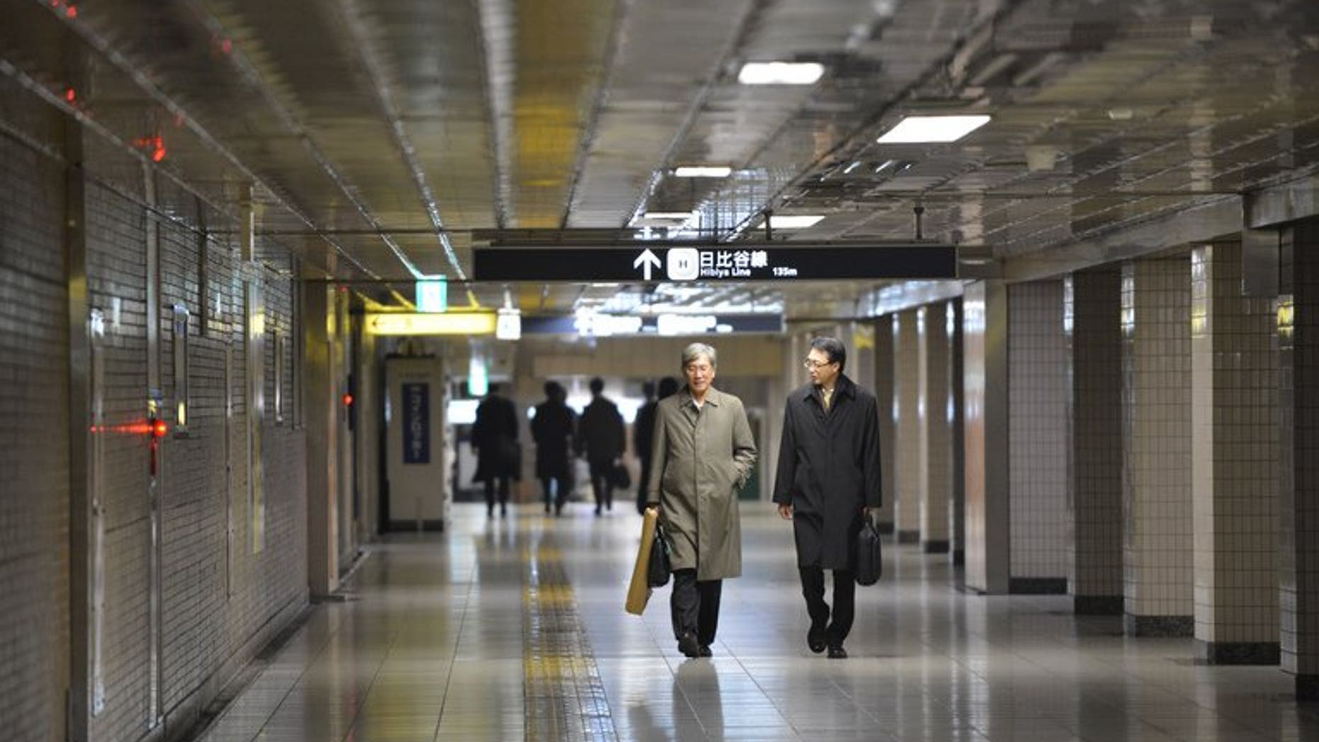 Businessmen walk on a concourse at a subway terminal in downtown Tokyo on December 28, 2012. Japan's army of dark-suited salarymen are scraping by on a monthly allowance from their wives that is less than half what they got in the 1980s bubble years, a survey has shown.