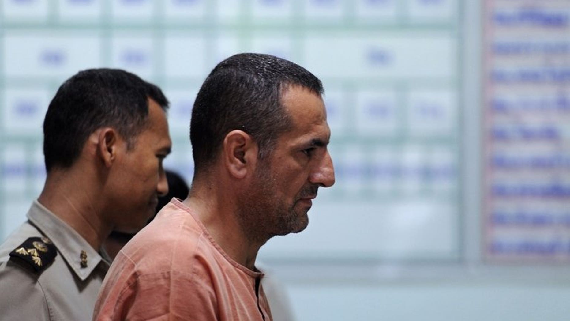 Lebanese-Swedish man Atris Hussein (centre) leaves a holding cell for the courtroom ahead of a scheduled hearing at a criminal court in Bangkok on June 11, 2013. Hussein on Tuesday denied links to the Hezbollah movement during his trial on charges of breaking Thailand's weapons laws.