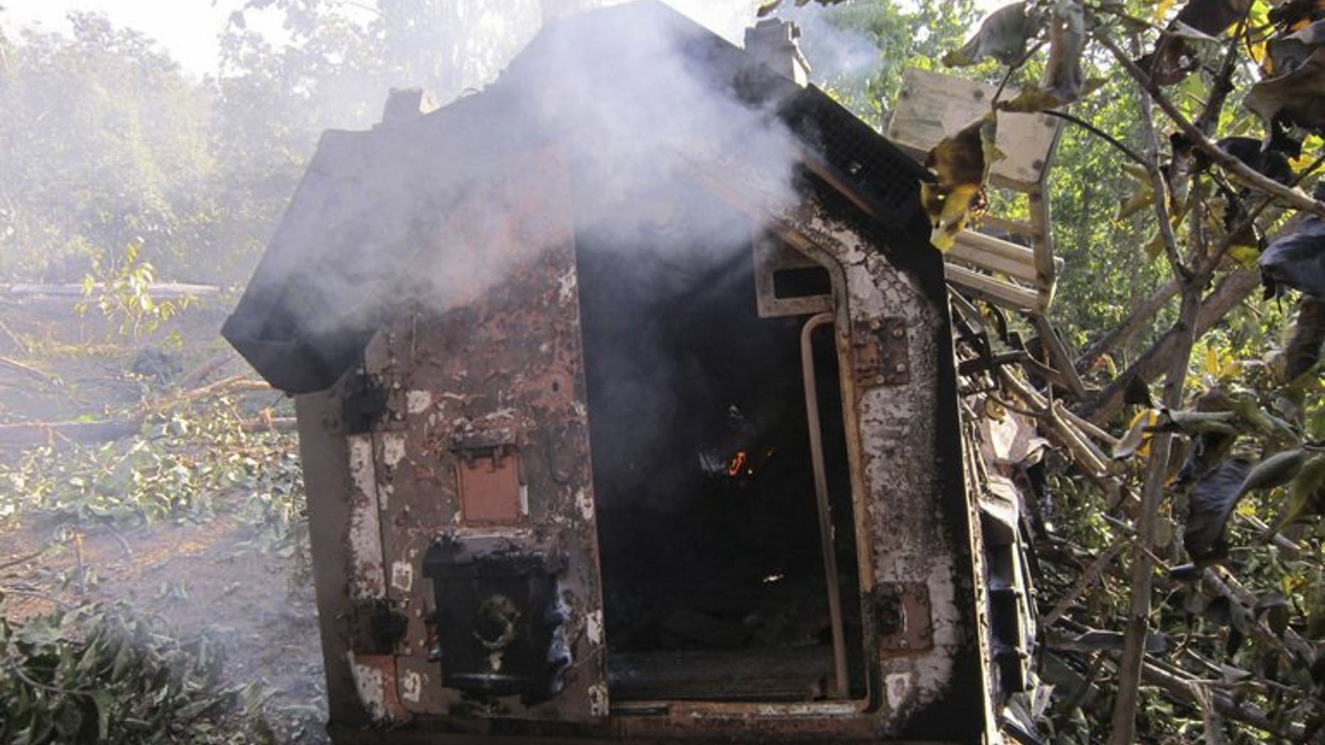 A smouldering police vehicle is seen following a landmine explosion in Garhwa district in India's Jharkhand state on January 21, 2012. A group of more than 50 Maoist guerrillas ambushed a police patrol in eastern India on Tuesday, killing the district police chief and four others, officials said.