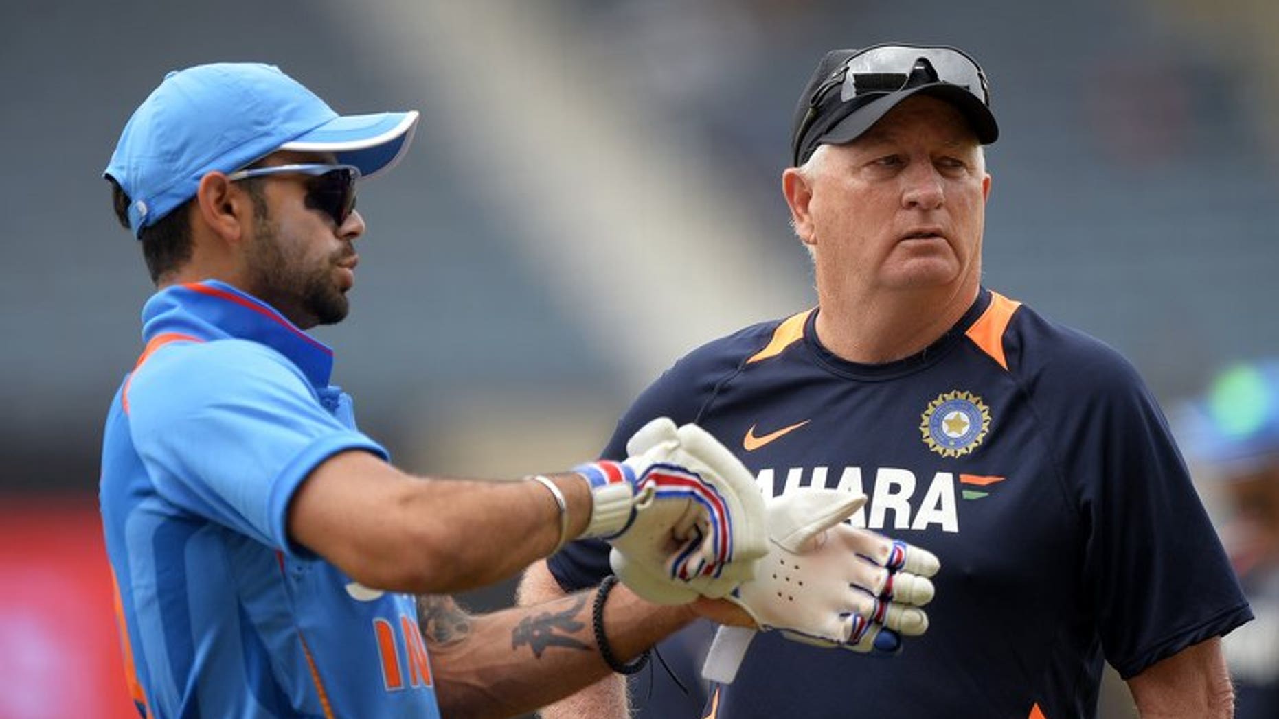Indian captain Virat Kohli (left) confers with coach Duncan Fletcher before the start of the Tri-Nation one-day match against Sri Lanka at the Sabina Park stadium in Kingston, on July 2, 2013. Indian won the toss and elected to field.