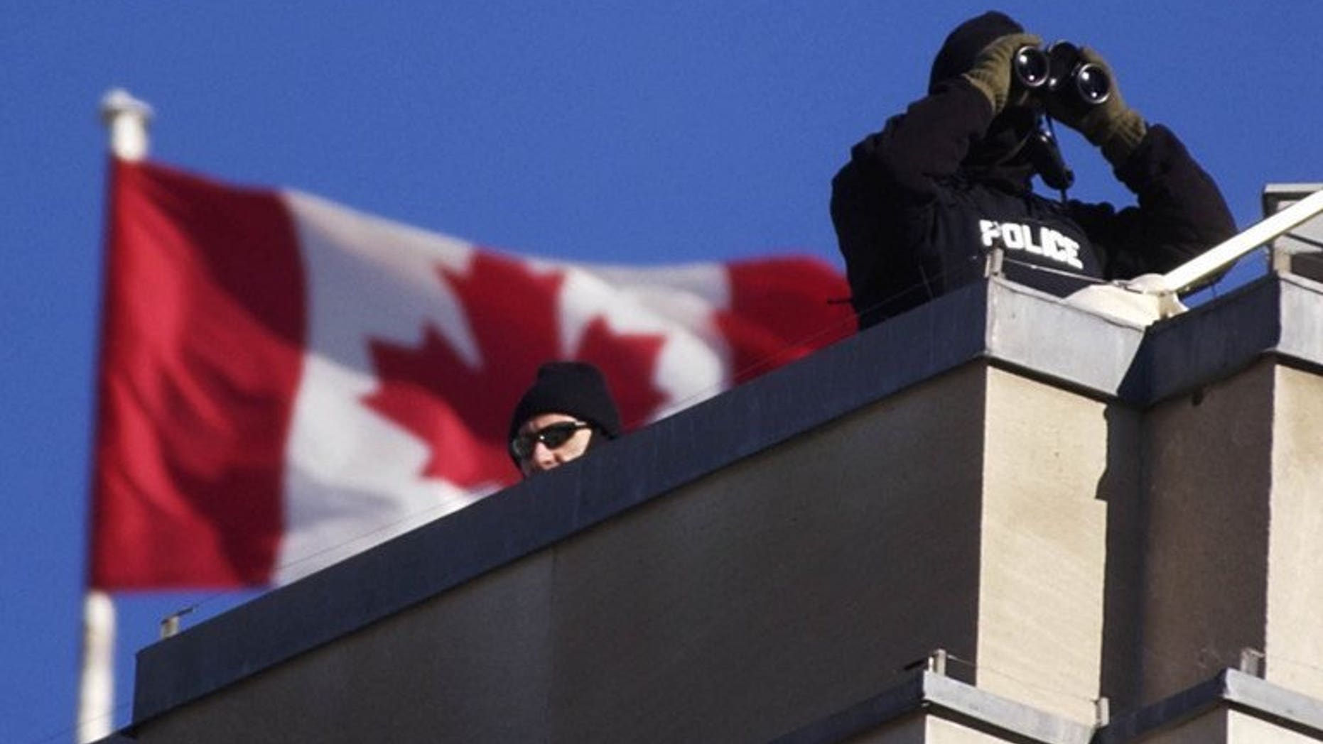 Royal Canadian Mounted Police team keep watch from the roof of the Government Conference Center, November 16, 2001. Canadian police said Tuesday they had arrested two people "inspired by Al-Qaeda" who allegedly plotted to bomb the provincial legislature in western British Columbia.