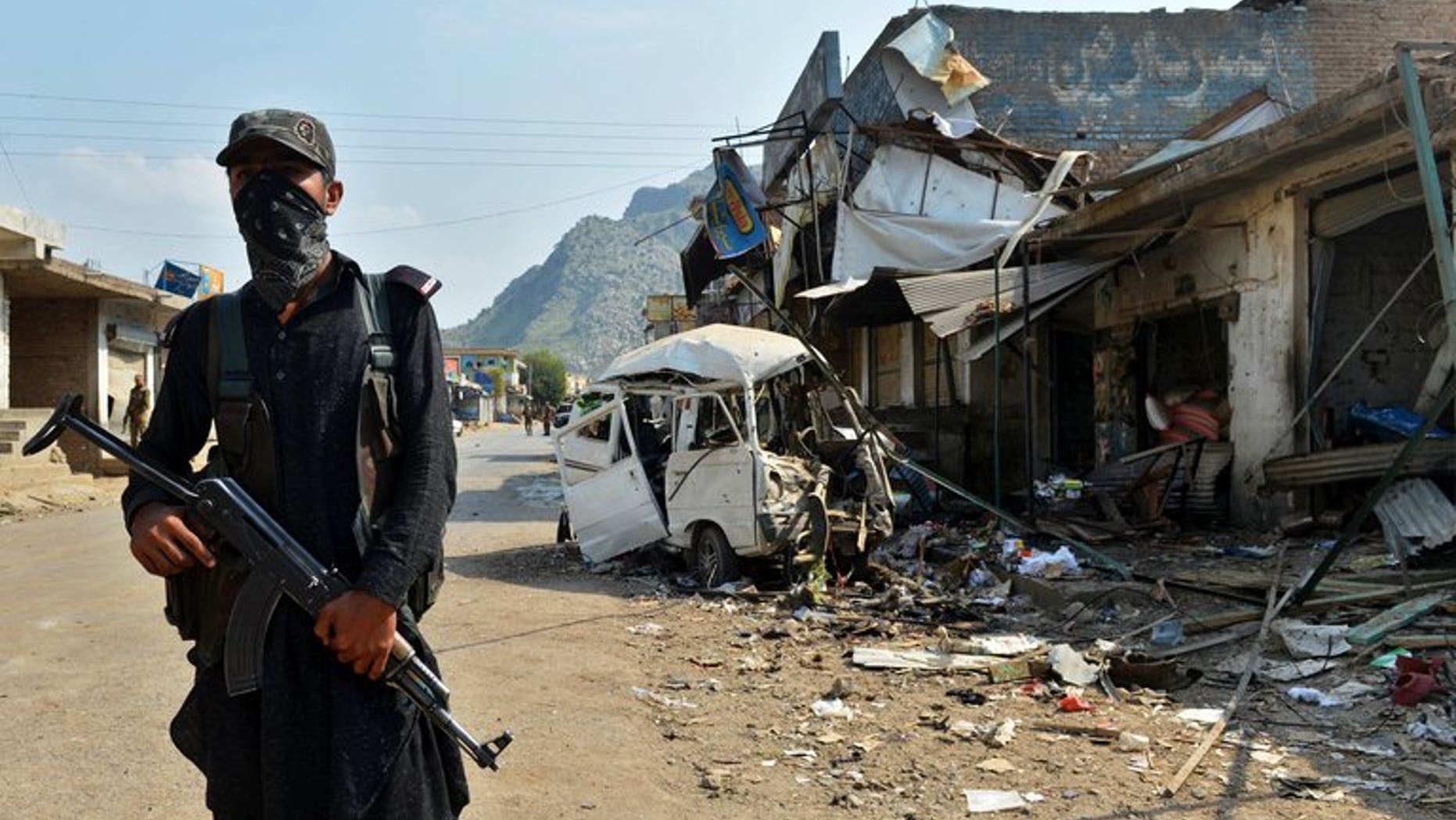 A Pakistani policeman stands guard at the site of a suicide bomb attack in Darra Adam Khel on October 13, 2012. Dozens of heavily armed militants stormed a checkpoint in the northwestern Pakistani tribal area, killing at least six paramilitary police.
