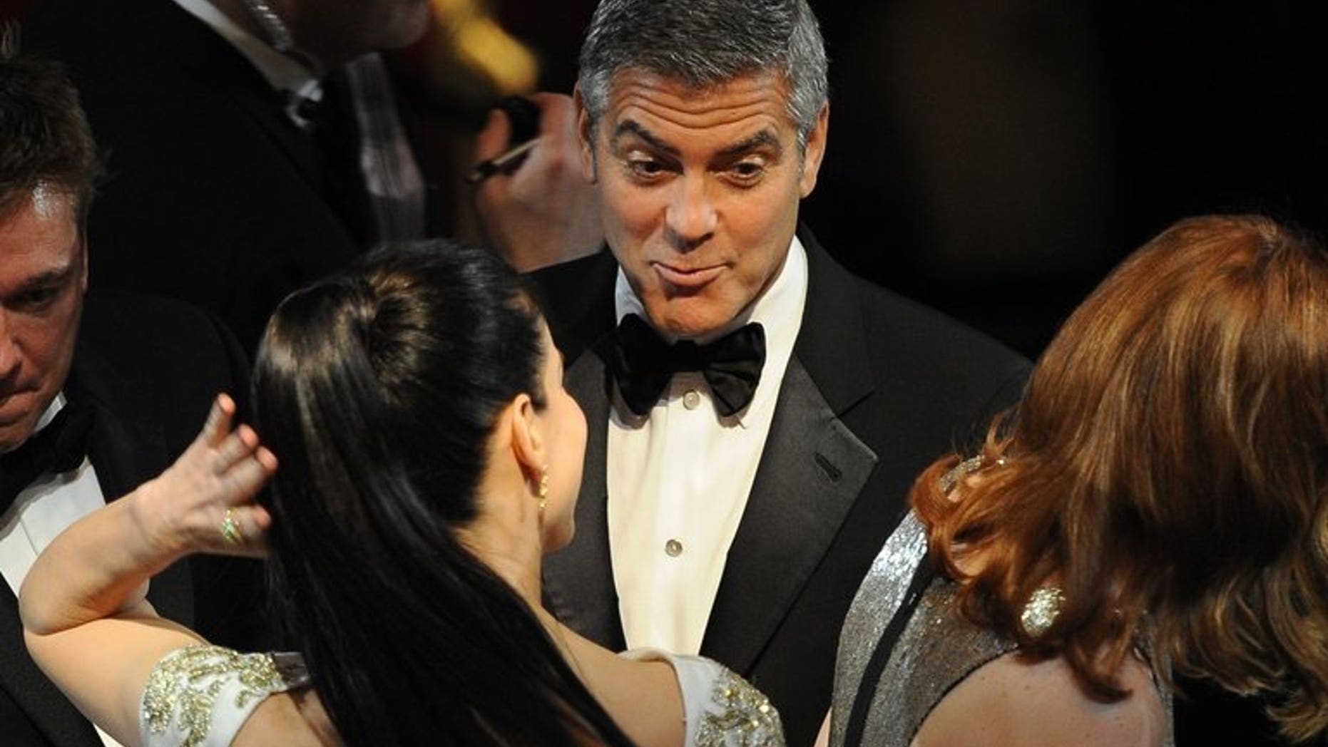 US actor George Clooney talks to actress Sandra Bullock (C) prior to the 84th Annual Academy Awards in Hollywood, California on February 26, 2012. Hollywood heavyweights Bullock and Clooney will open the Venice film festival next month with their new movie "Gravity" where they play two astronauts on an ill-fated mission.