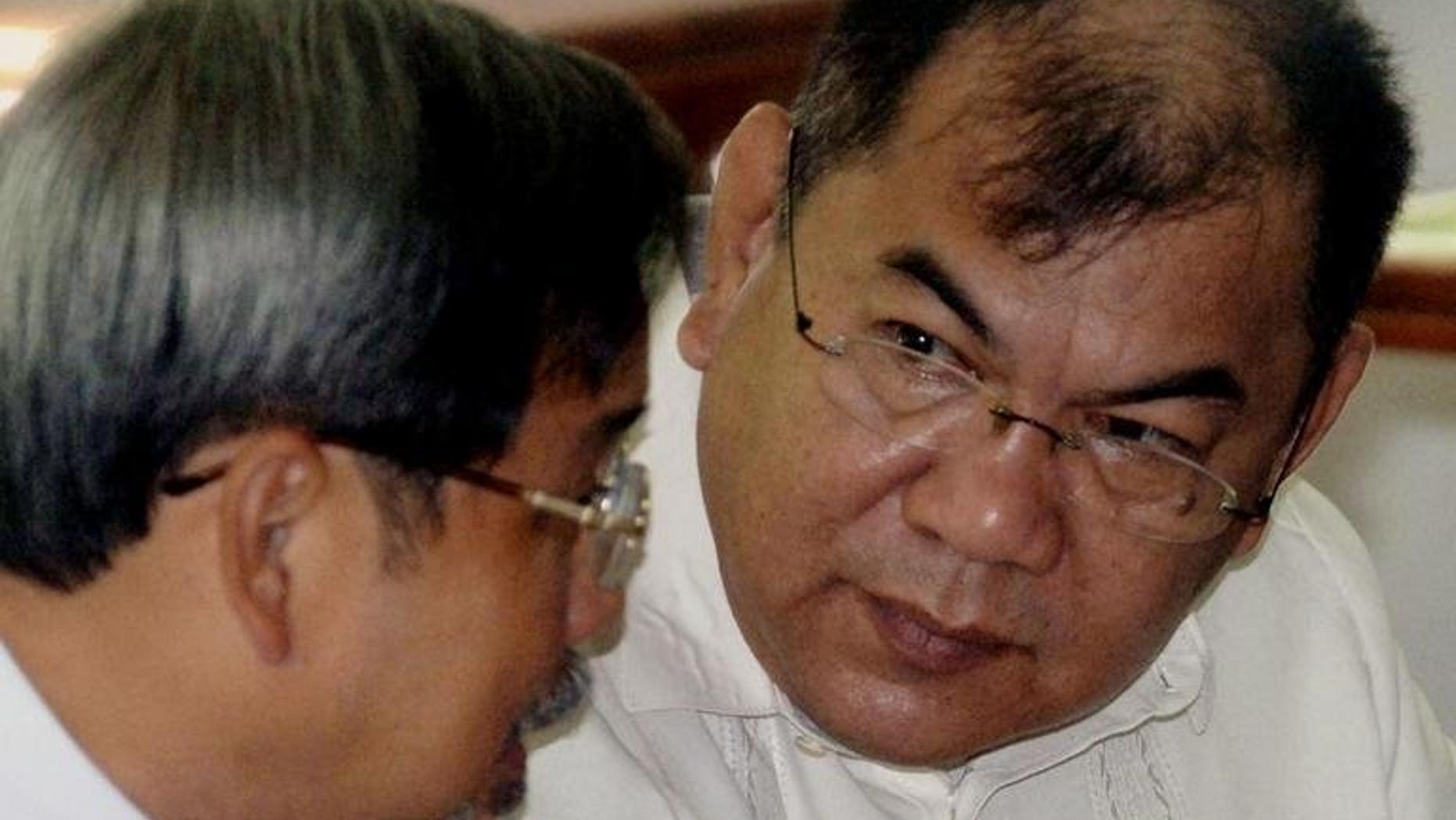 Former military finance official Major General Carlos Garcia (right) talks to his lawyer in a hearing room at a military court in Manila on December 2, 2005. The Philippine Supreme Court on Wednesday blocked efforts by a senior general facing massive graft charges to enter a plea bargain which would have let him post bail and walk free in a few years, keeping much of the money.