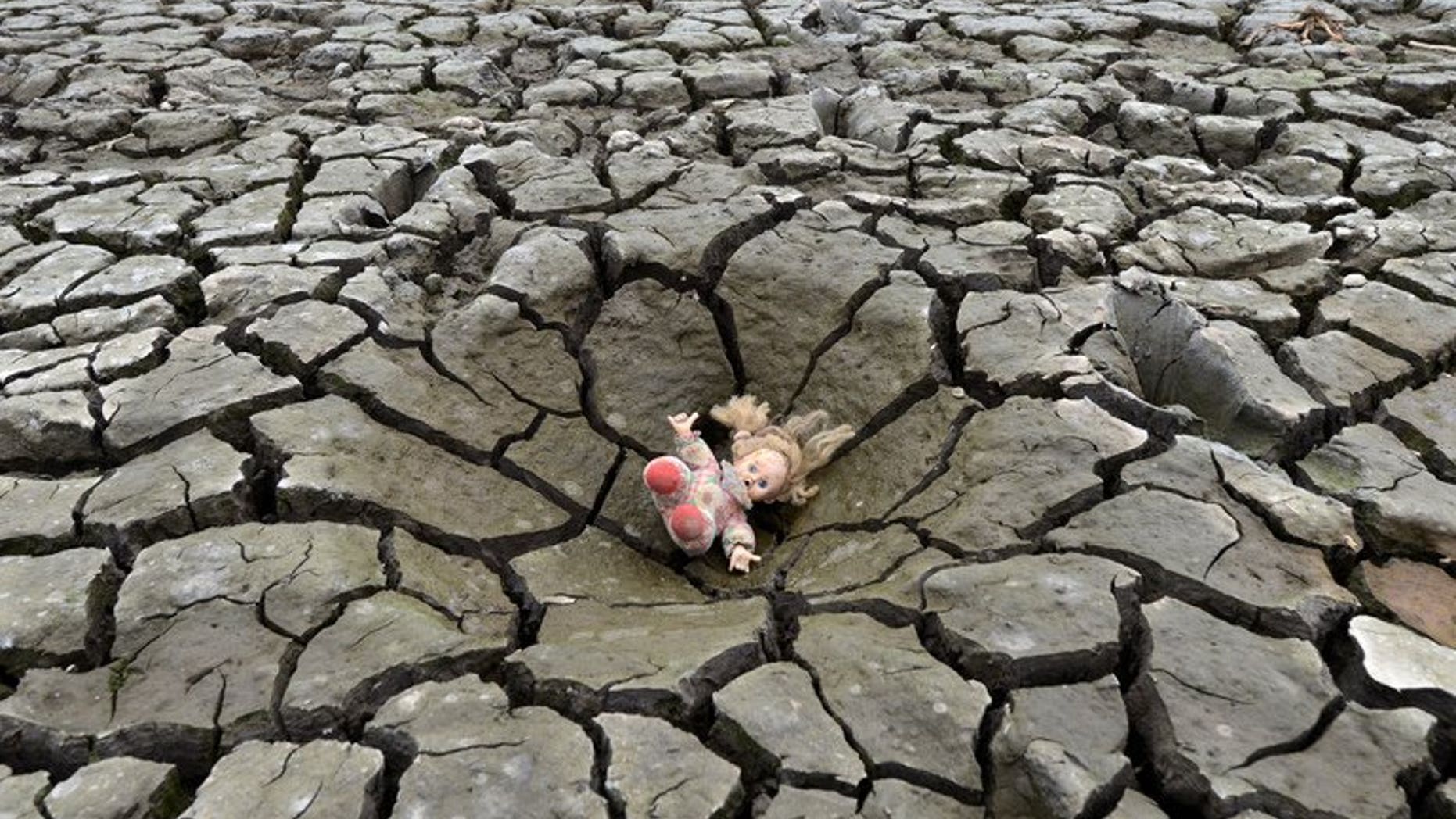 A doll lies on a hole in the dry soil of Los Laureles dam, southern Tegucigalpa, in Honduras on May 22, 2013. The first decade of the 21st century was the hottest on record, marked by unprecedented climate and weather extremes that killed more than 370,000 people, the United Nations weather agency said Wednesday.