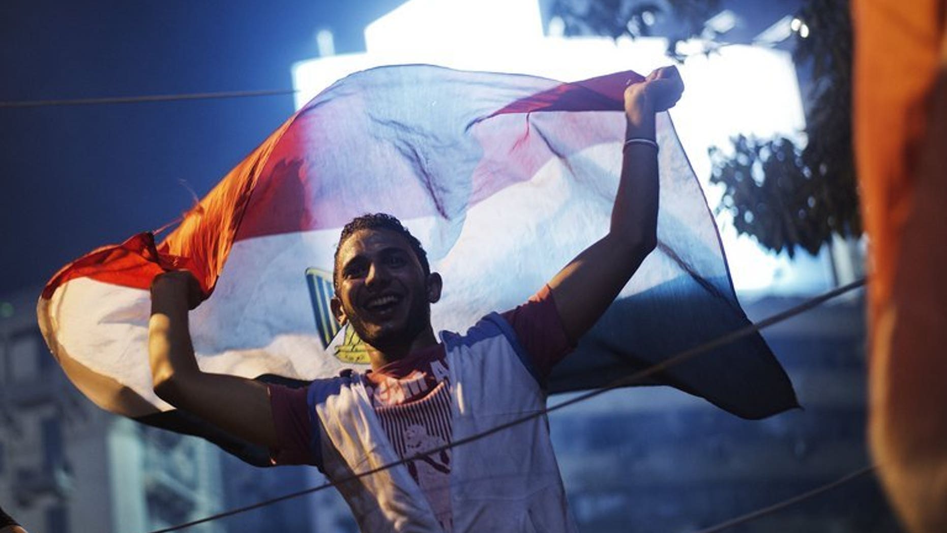 People celebrate in Tahrir Square after a broadcast confirming that the army will temporarily be taking over from the country's first democratically elected president Mohammed Morsi on July 3, 2013 in Cairo. Britain urged for calm in Egypt following the army's ouster of Morsi and spoke out against the use of military intervention in bringing about regime change.