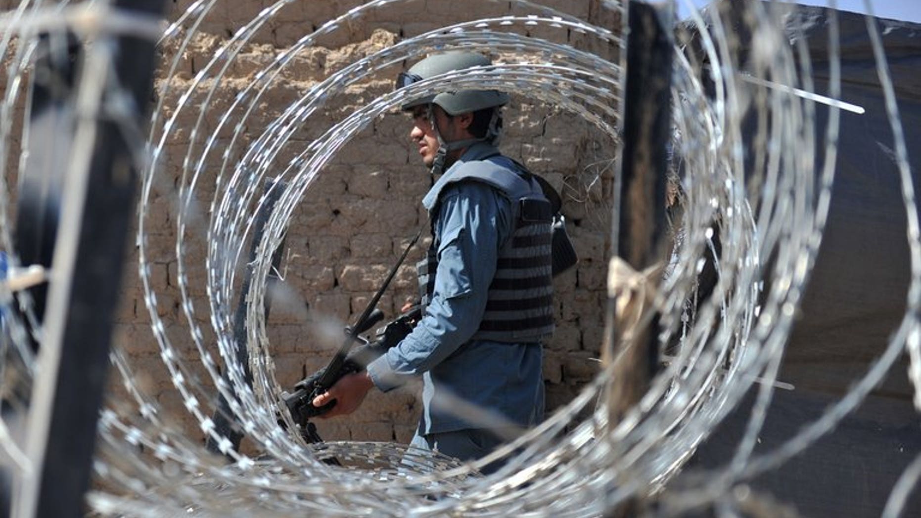 An Afghan policeman patrols in Helmand Province on June 19, 2012. A bomb attack killed four girls attending an Afghan wedding, officials said Thursday, blaming the attack on Taliban rebels intending to target government employees at the event.
