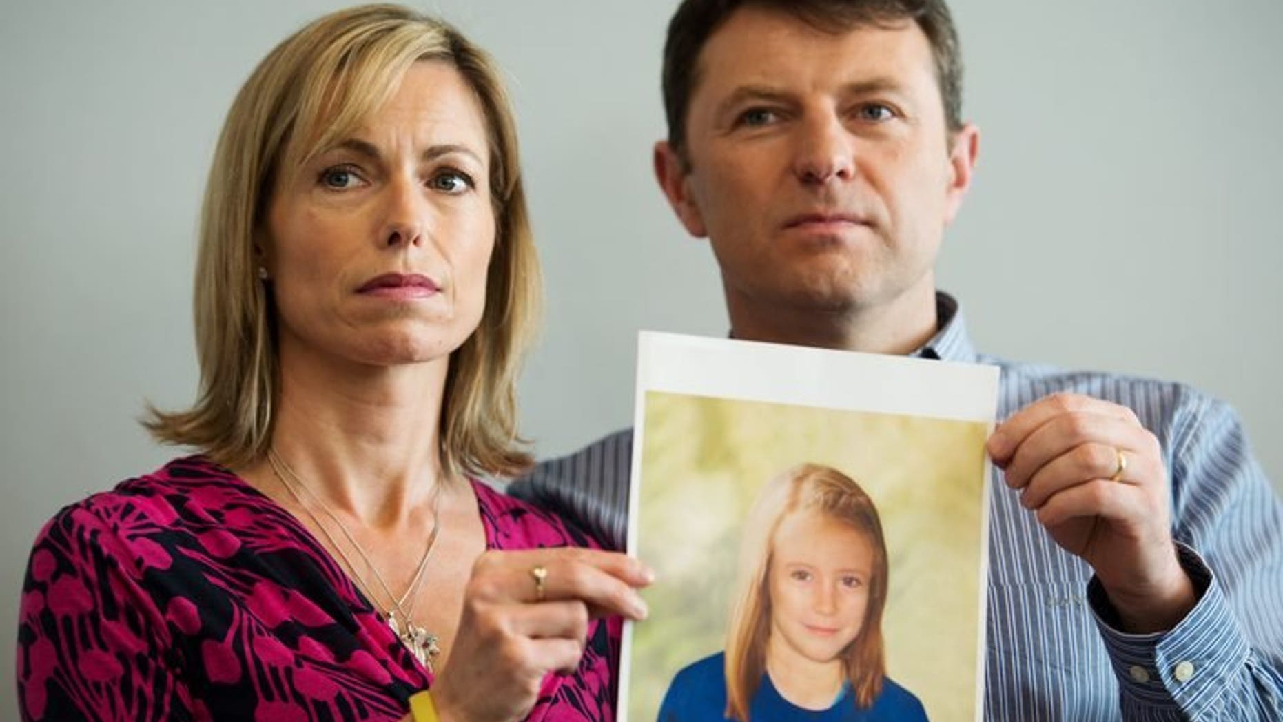 Parents of missing girl Madeleine McCann, Kate (L) and Gerry McCann (R) pose with an artist's impression of how their missing daughter might look on May 2, 2012. Police are opening their own investigation into the toddler's 2007 disappearance in Portugal and have identified 38 "persons of interest" across Europe.