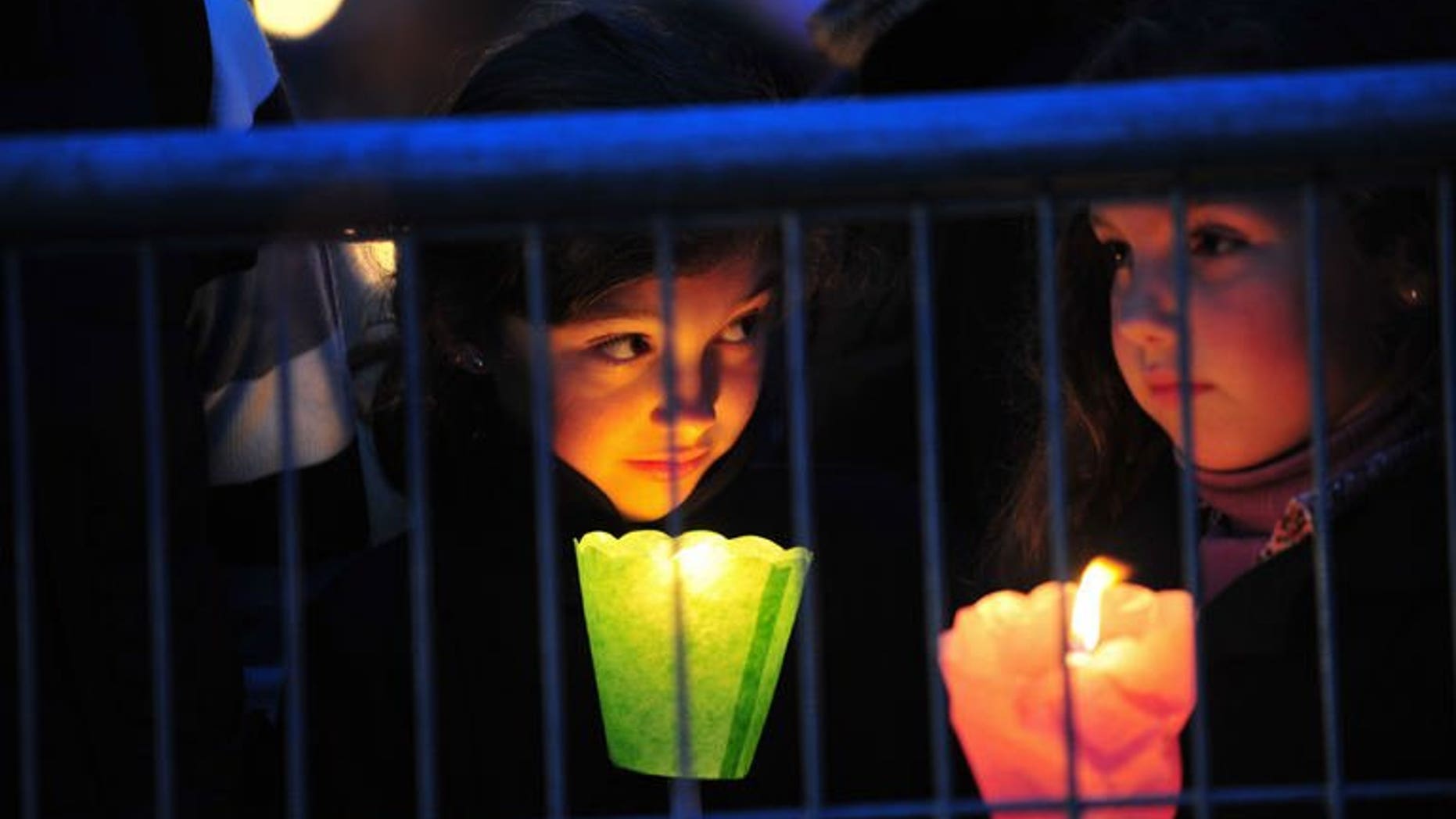 Children hold candles during a prayer vigil at the ancient Circus Maximus Arena in Rome on April 30, 2011, on the eve of the beatification of the late Pope John Paul II. Late popes John Paul II and John XXIII will be made saints of the Roman Catholic Church, the Vatican said on Friday in a widely-awaited announcement, without specifying when the canonisations will occur.