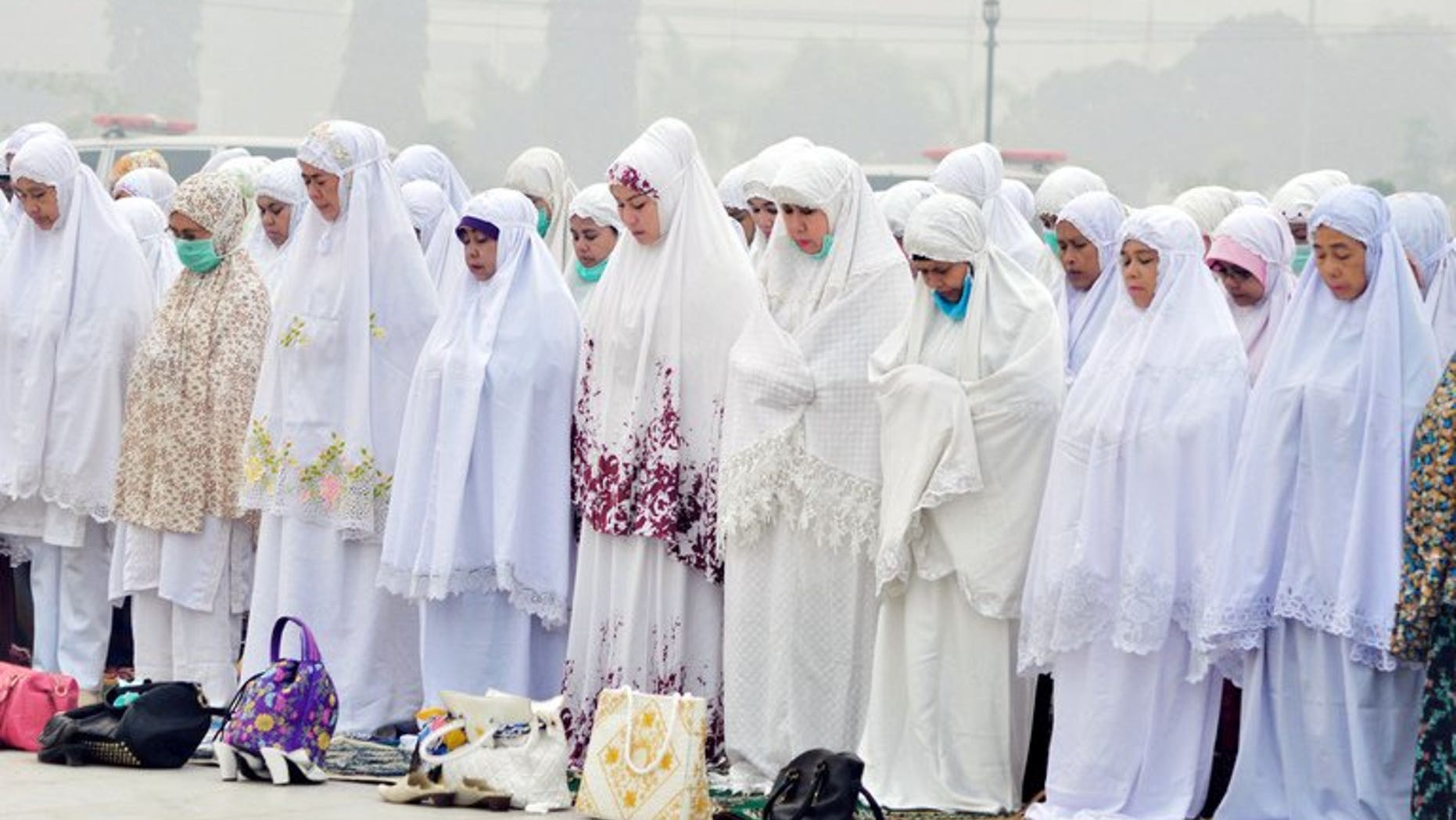 Indonesian Muslim women take part in mass prayers asking for rain at a square covered by thick haze in Dumai on June 25, 2013. Sales and distribution of alcohol could be banned in some parts of Indonesia after Muslim hardliners won a Supreme Court victory, an official said Friday.
