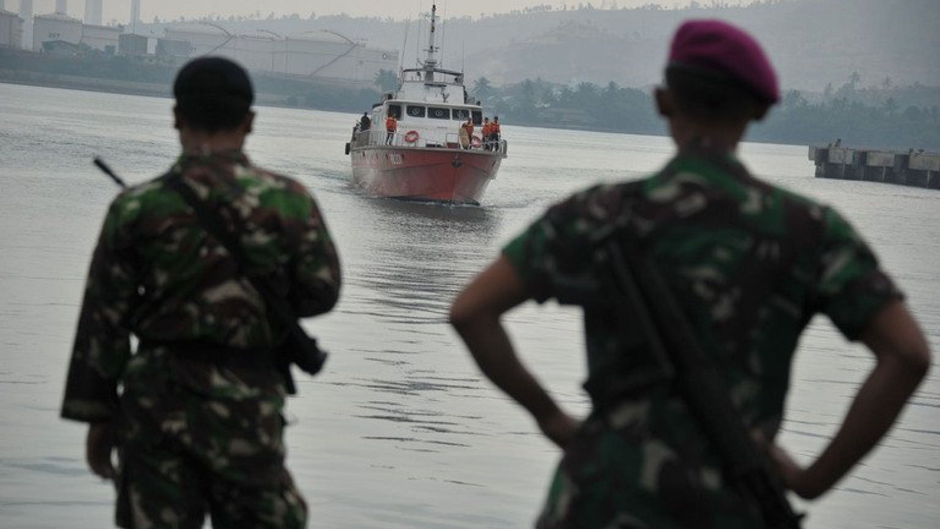Indonesian marines look towards a rescue boat carrying asylum-seekers at Merak seaport on August 31, 2012. A people-smuggling boat carrying about 80 asylum-seekers broke down in seas south of Indonesia on Friday, prompting several vessels to divert in a bid to help it, Australian and Indonesian officials said.