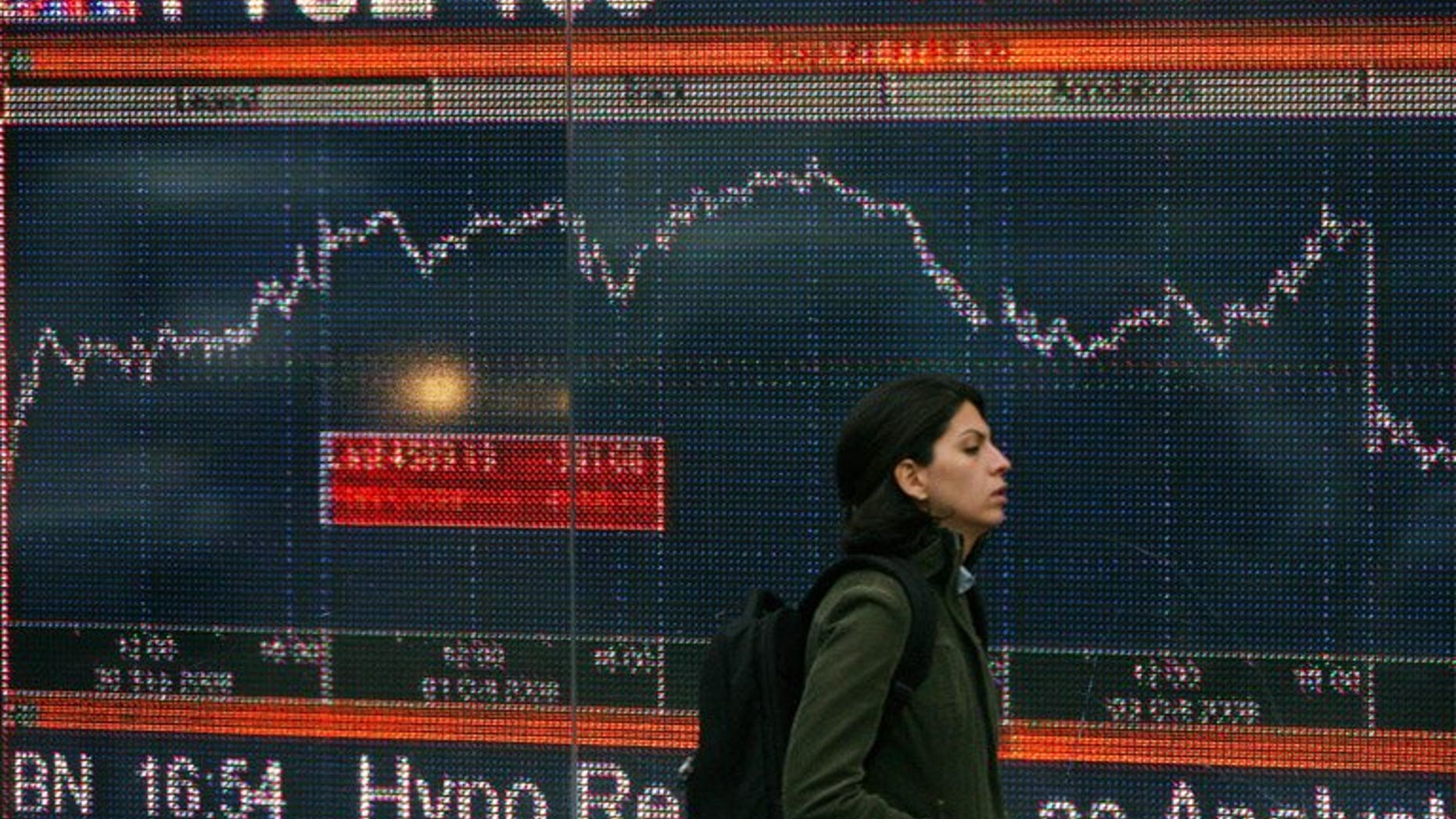 A woman walks past an electronic sign showing the FTSE 100 index in London in October 2008.