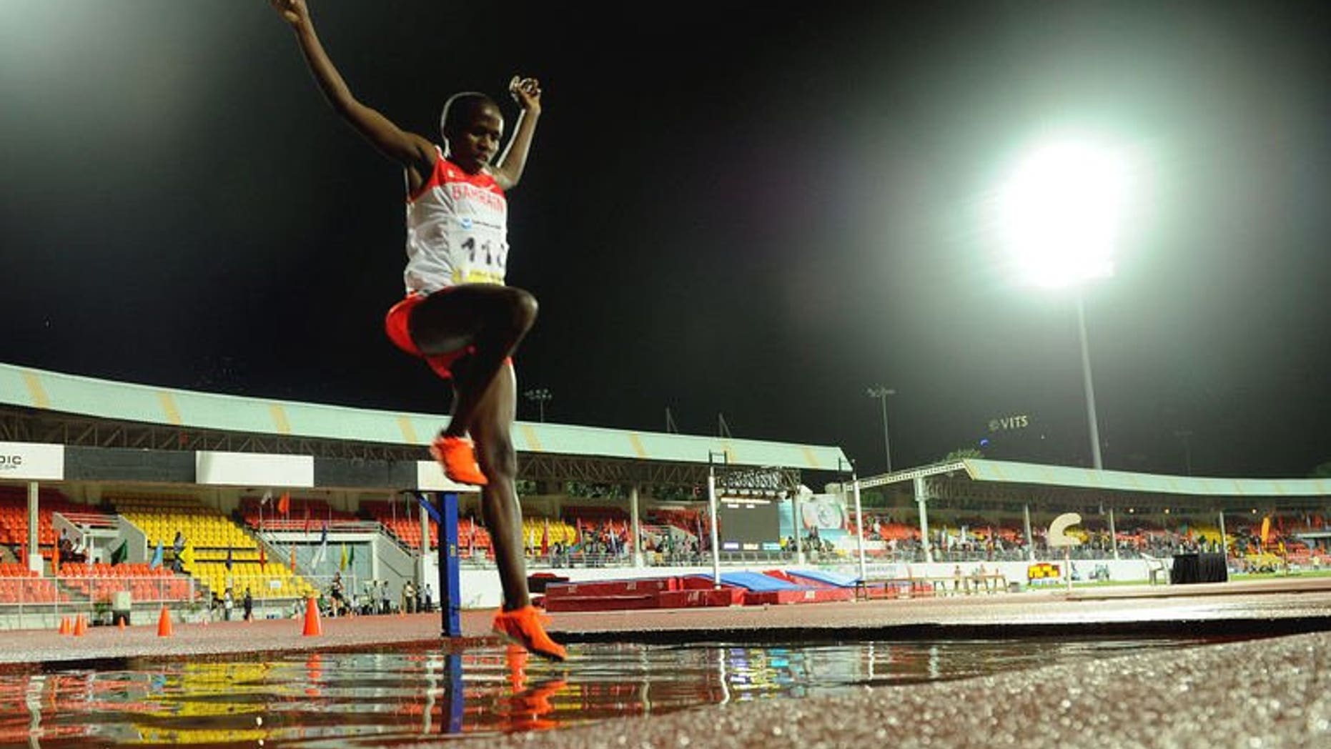 Ruth Jebet leaps over a puddle in the women's 3000 meters steeplechase during the third day of the five-day Asian Athletics Championship 2013 at the Chatrapati Shivaji Stadium in Pune on July 5, 2013.