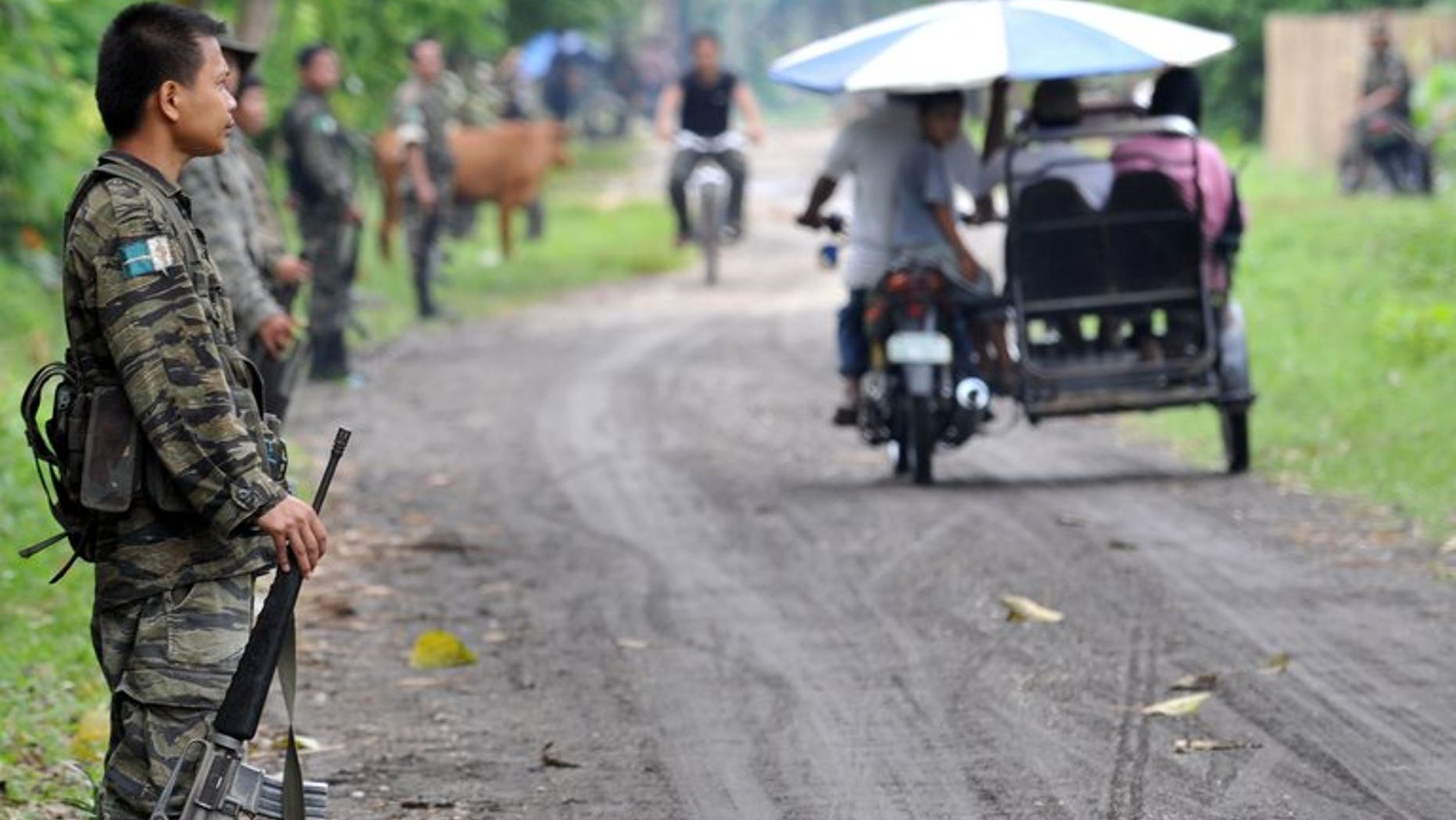 This file photo shows members of the southern Philippine rebel group, the Moro Islamic Liberation Front (MILF), lining a street as villagers pass by, in a town on Mindanao island, on September 19, 2009. The United States has warned Americans against travel to the southern Philippines just days after Australia and Canada issued similar advice.