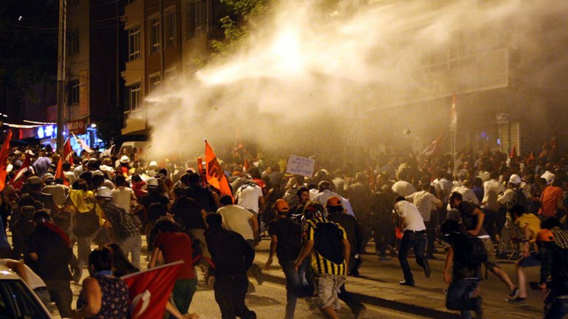 Protesters take cover from water cannon during clashes with police in Ankara on June 25, 2013. The Council of Europe's human rights commissioner Nils Muiznieks has urged an investigation into the use of excessive police force during a crackdown on anti-government protests in Turkey last month.