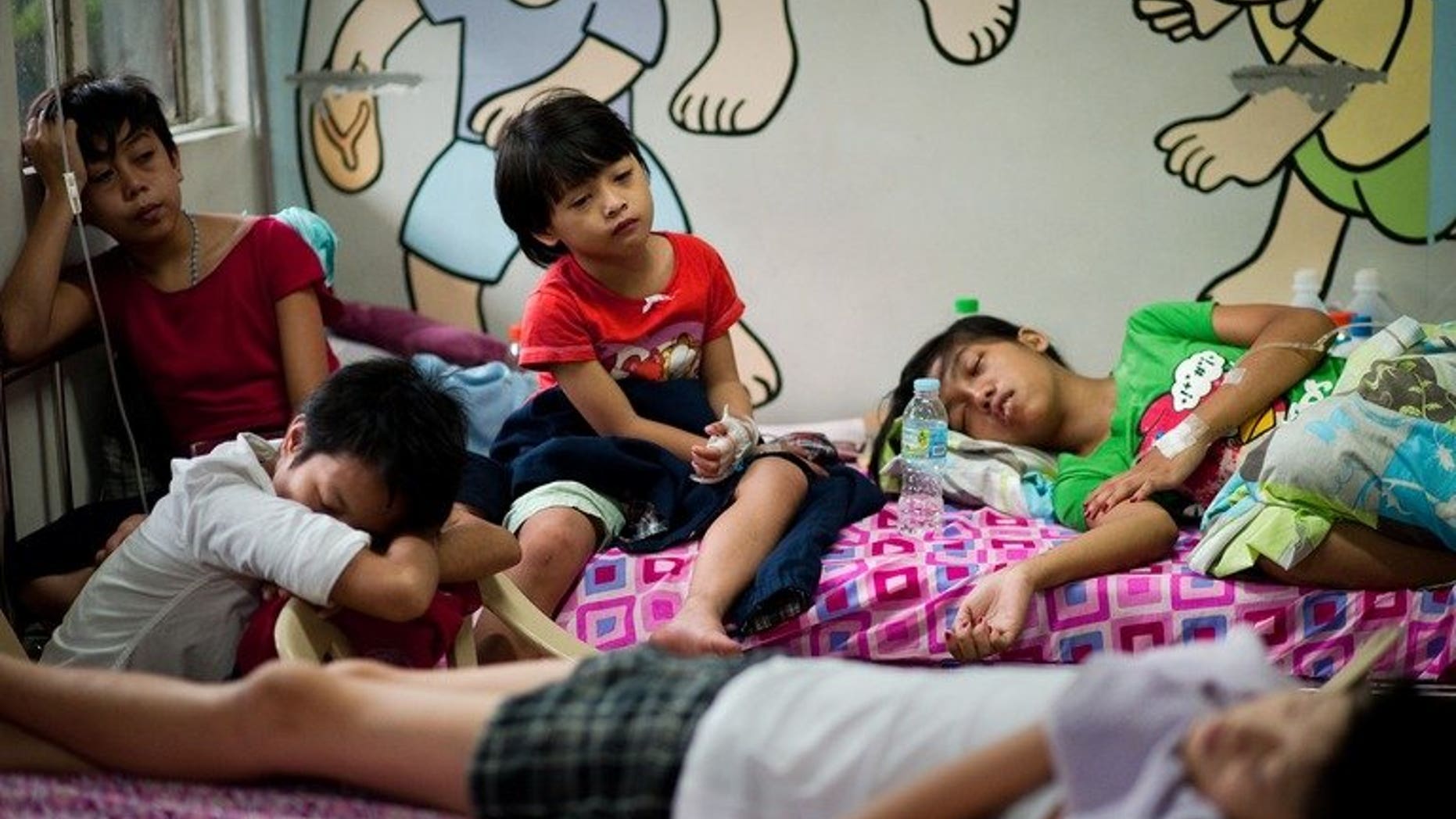 Patients with dengue fever share beds at a hospital in Quezon city, in the suburbs of Manila, on August 14, 2012. Dengue fever has surged in the central Philippines, infecting more than 1,800 people and killing at least ten, a provincial official says.