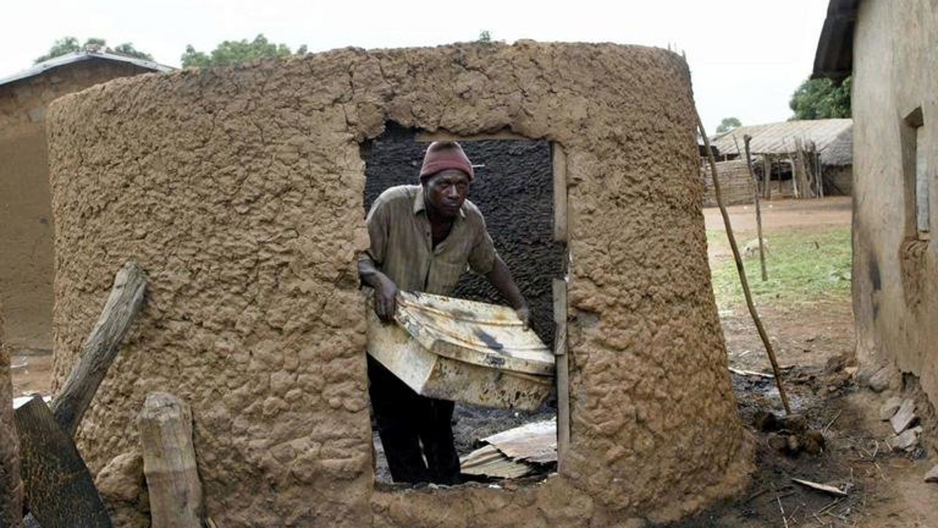 Monday Longshak in his burnt mud house at Sabon Gida in Quanpan district in May 2004 after a raid by Fulani herdsmen. Gunmen suspected to be ethnic Fulani herdsmen invaded a farming village in restive central Nigeria's Benue State, burning several houses, police said Saturday, amid reports that at least 20 people died in the violence.